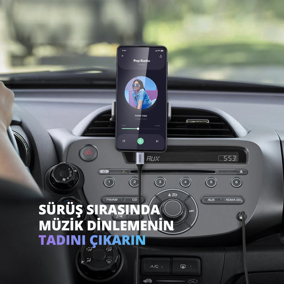 Araba gösterge panelinde müzik uygulaması arayüzü olan akıllı telefon.