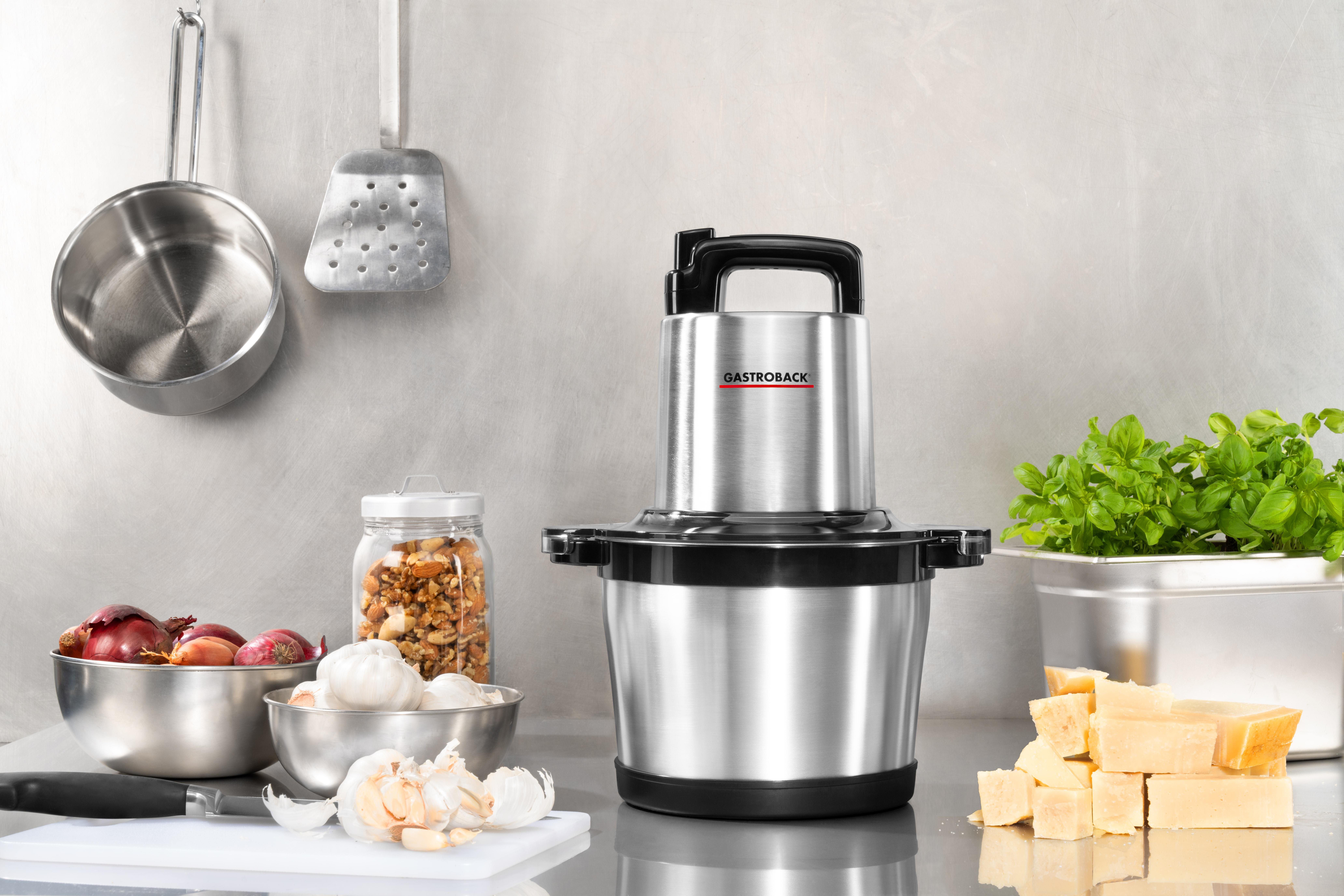 Küchenmaschine mit Zutaten auf einer Küchentheke, Edelstahl und Schwarz, Produktaufnahme.