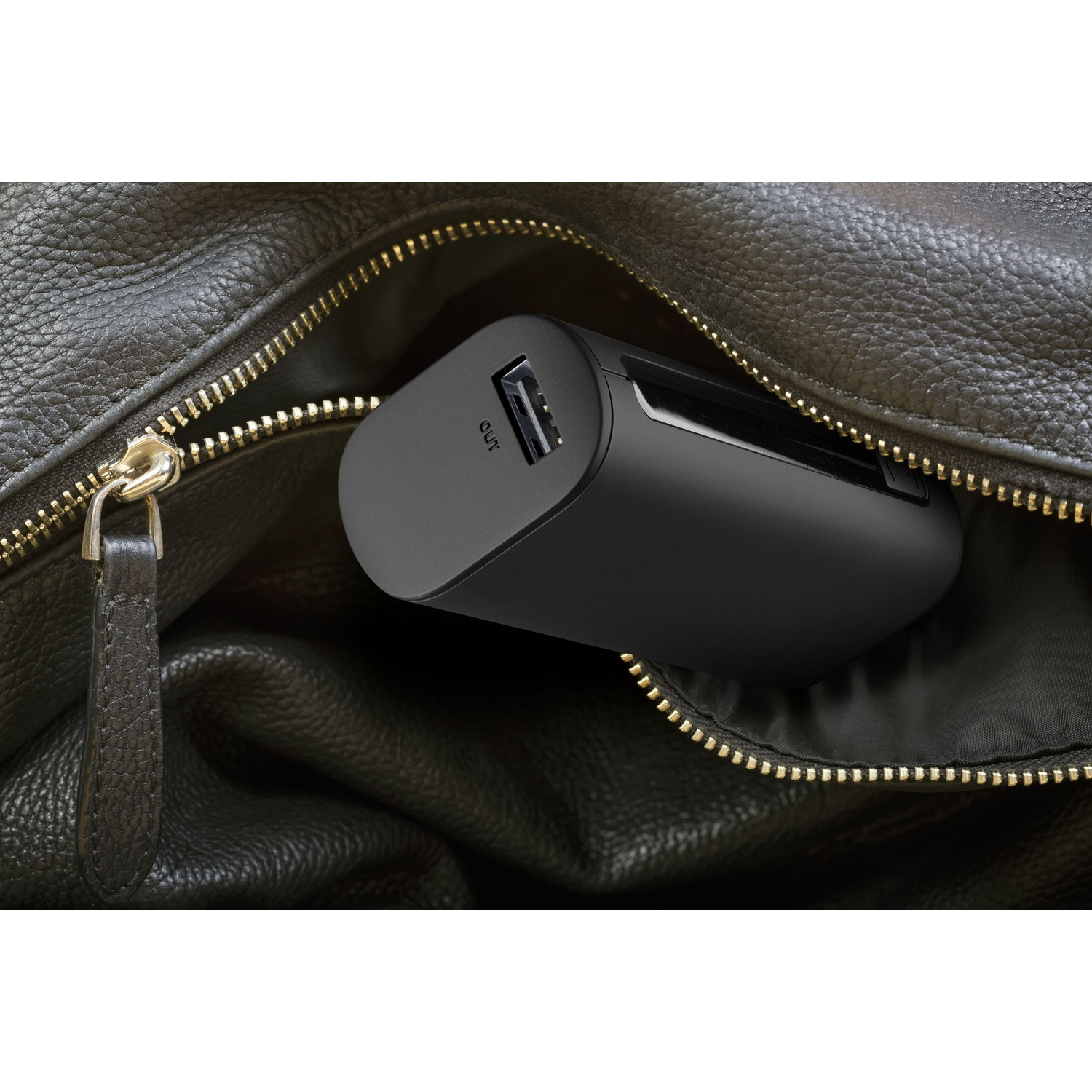 Un power bank nero in una borsa di pelle marrone, con una cerniera parzialmente aperta, che mostra la porta OUT.