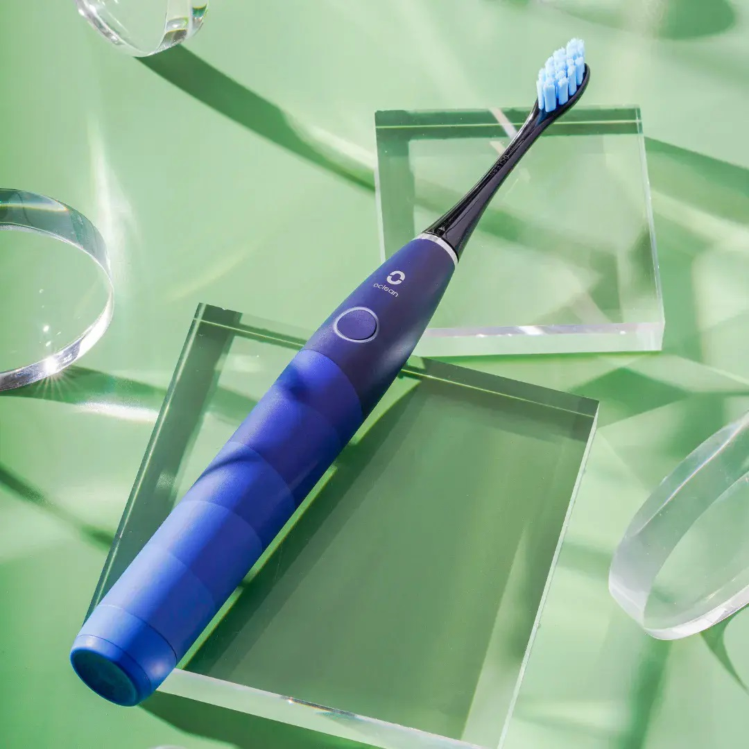 Szczoteczka elektryczna. Niebieski, czarny i srebrny design. Niebieskie włosie. Szklane bloki.