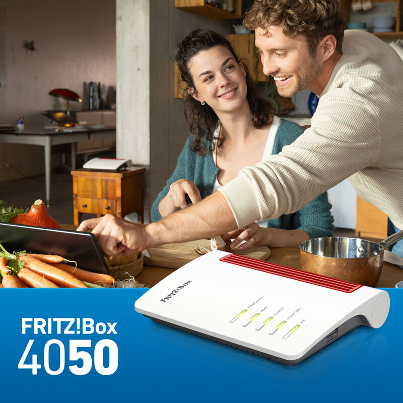 Paar benutzt Tablet in Küche. Router davor mit Text 'FRITZ!Box 4050'.