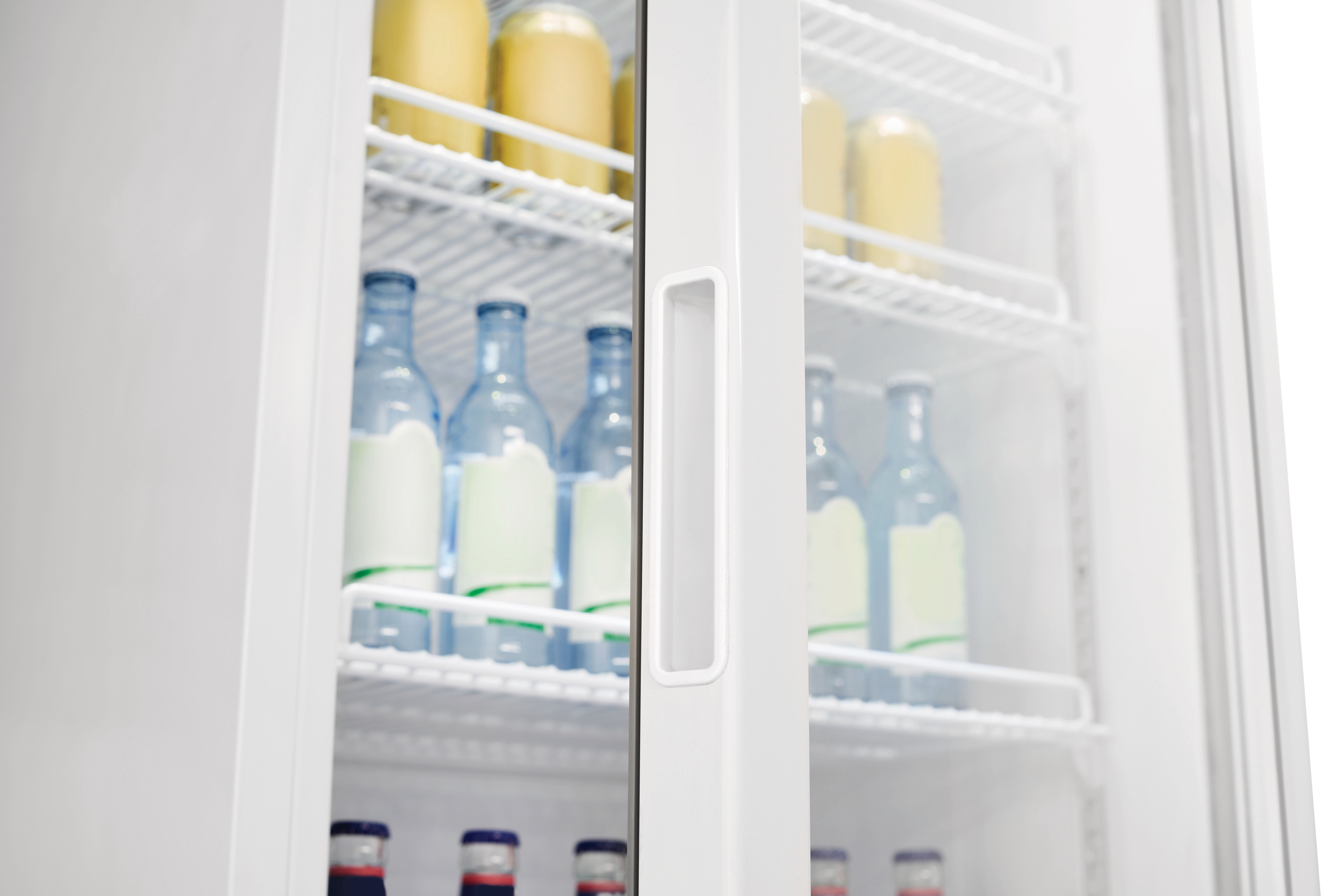 Ein Kühlschrank mit Flaschen und Gläsern. Die Tür ist angelehnt und zeigt den Inhalt auf weißen Regalen.