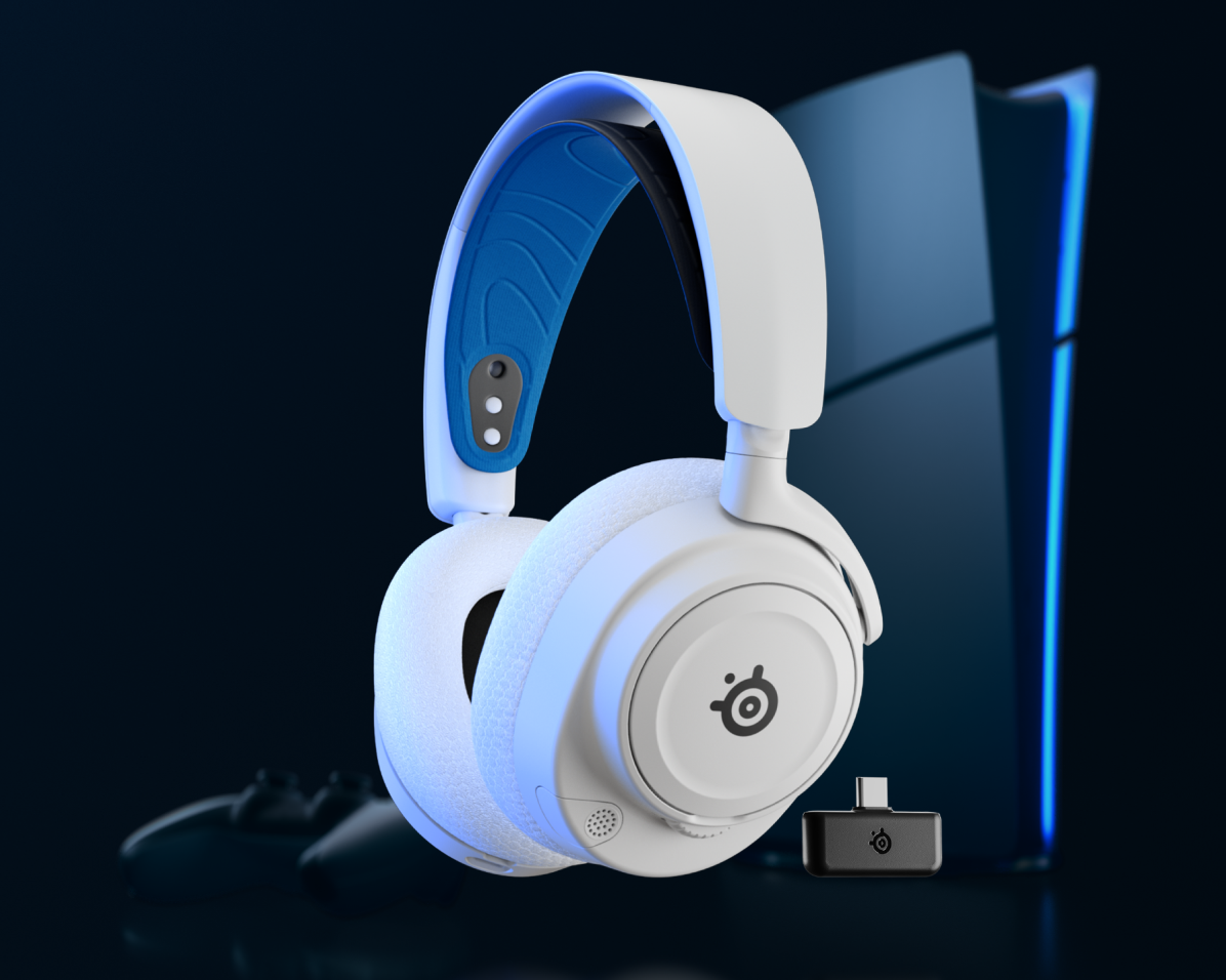 Fehér gamer fejhallgató kék díszítéssel, vezeték nélküli adapterrel és PlayStation 5 konzollal.