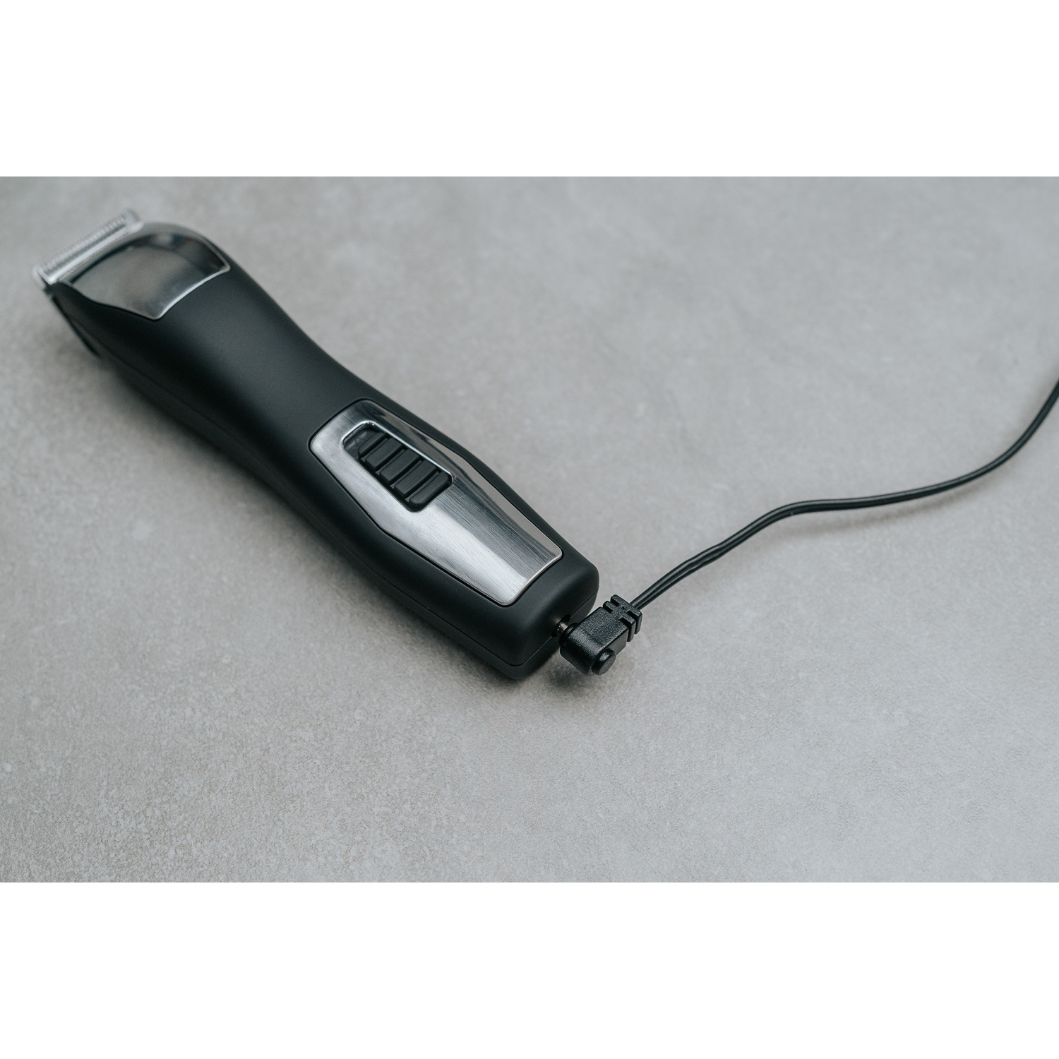 Tosatrice nera con dettagli argento, collegata a superficie grigia.