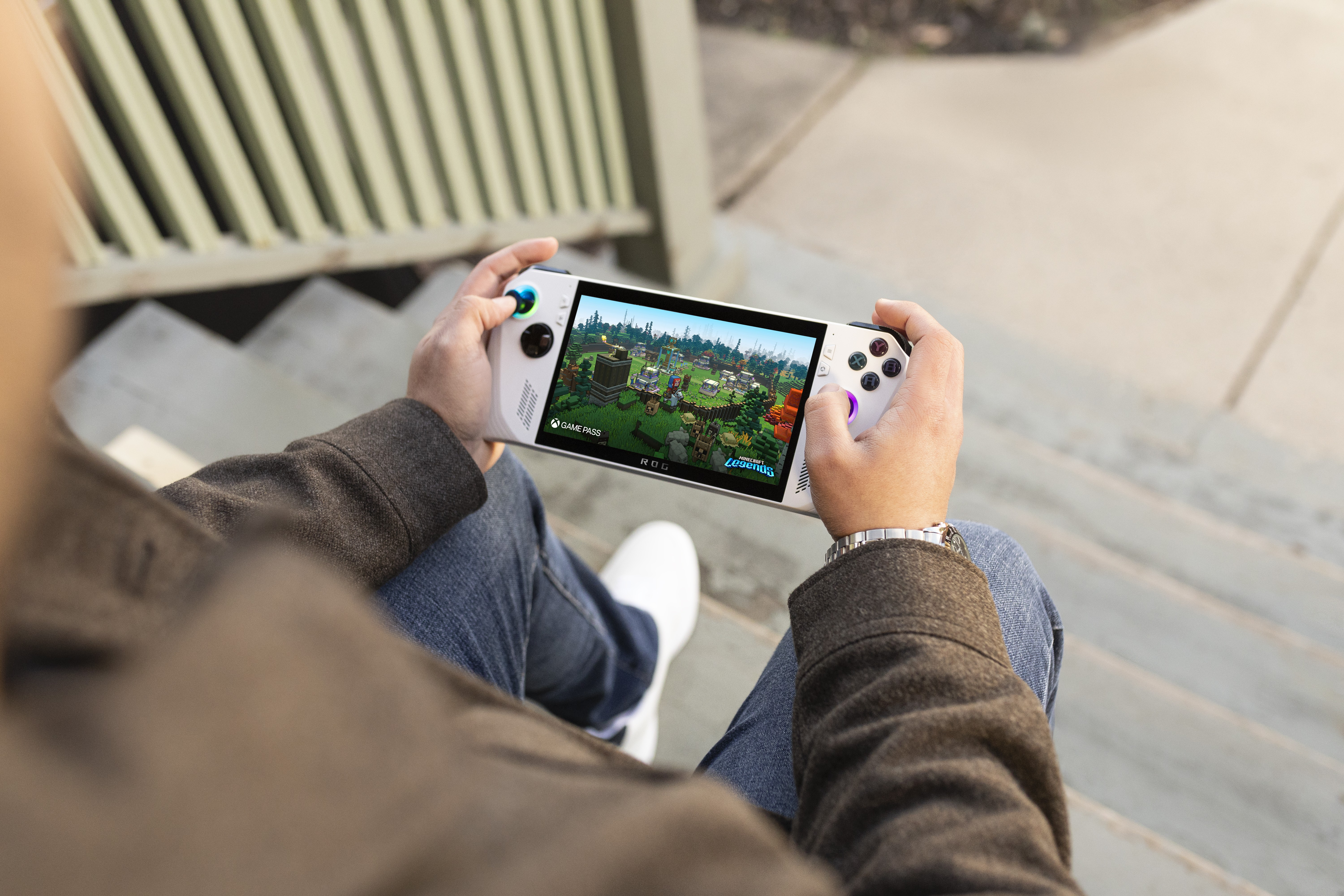 Persona jugando en un dispositivo portátil mientras está sentado en escalones.