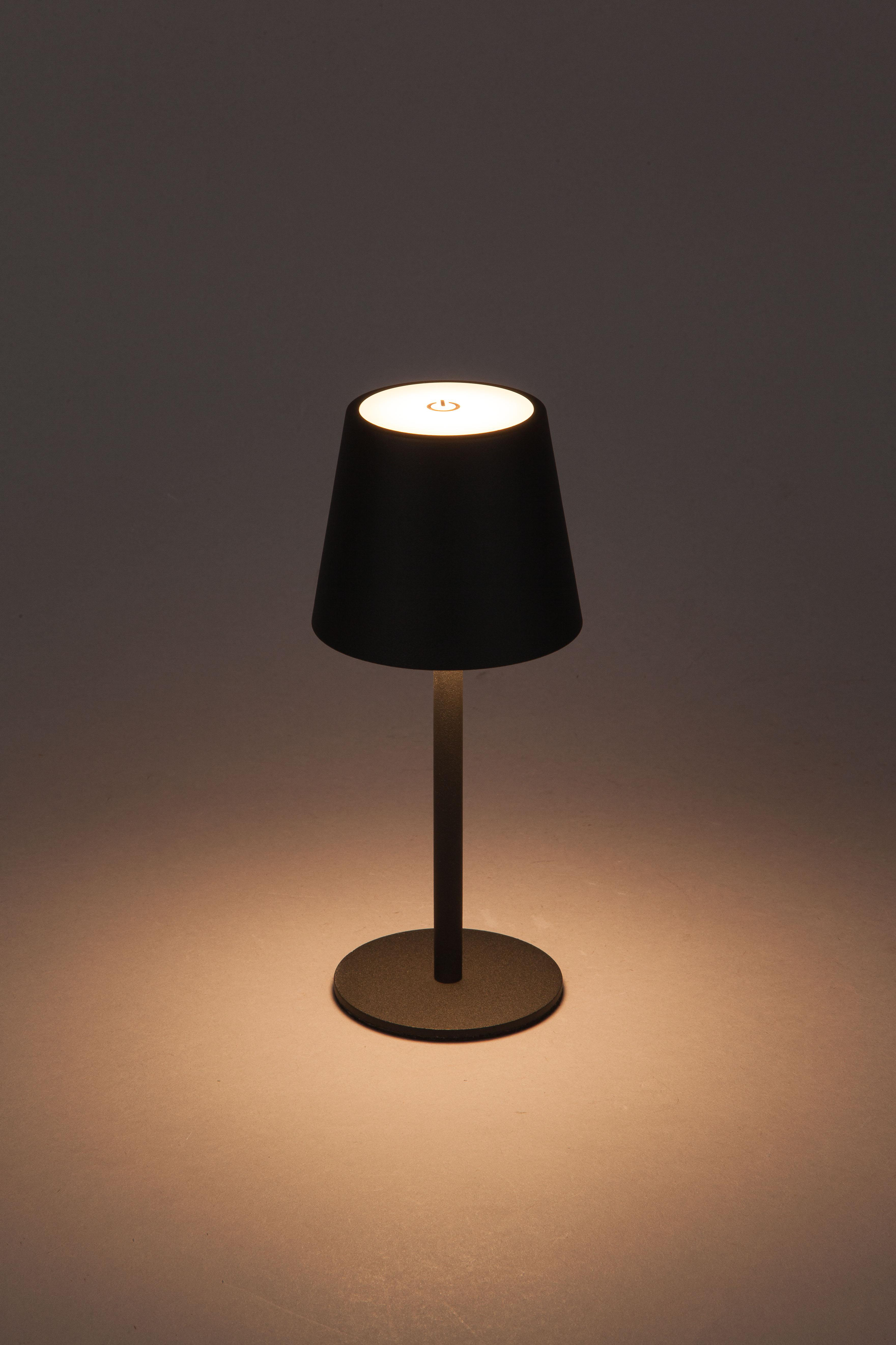 Schwarze Lampe mit beleuchteter Oberseite und rundem Sockel, die Licht wirft.