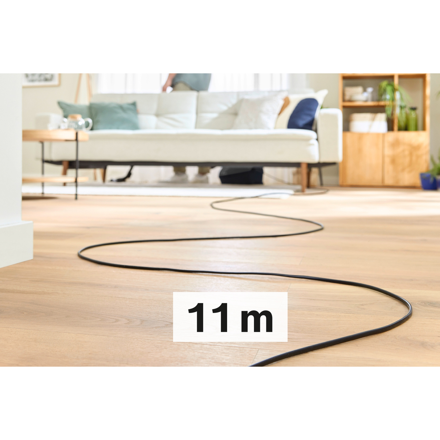 Zwarte kabel op houten vloer met bordje '11 m'.