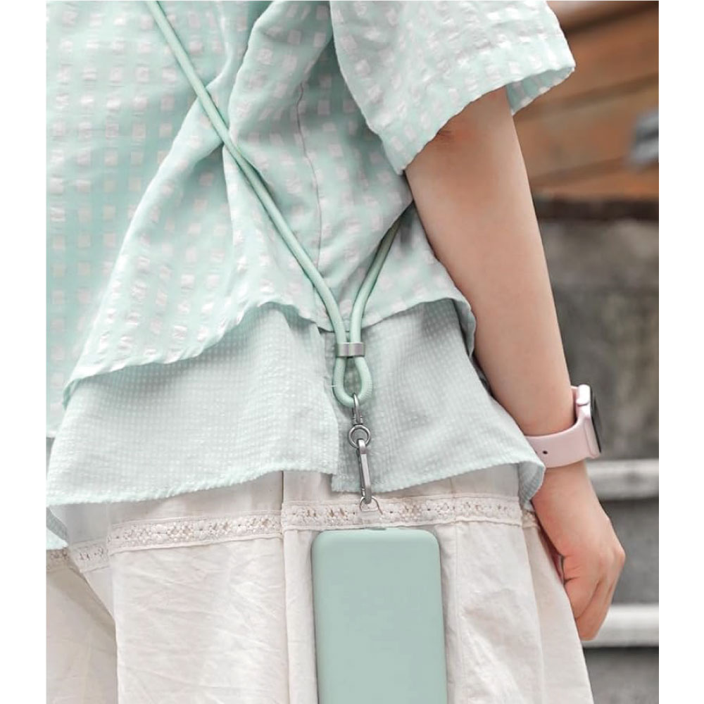 Una persona con una camisa azul claro y un teléfono con cordón. Un reloj rosa en su muñeca.