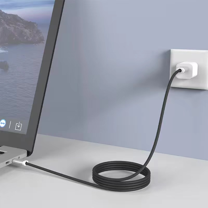 Portátil conectado a una toma de corriente mediante un cable de carga negro.