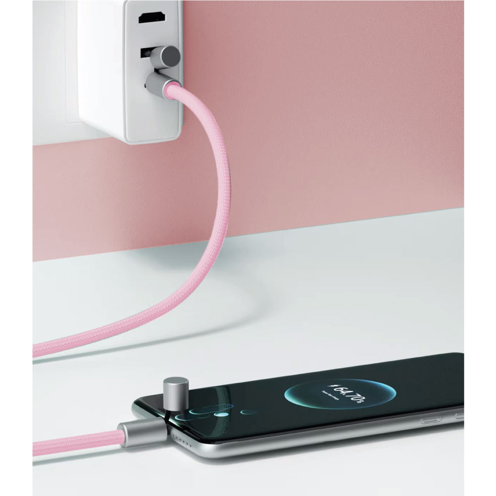 Un teléfono cargándose con un cable rosa. Un cargador blanco está enchufado a la pared.