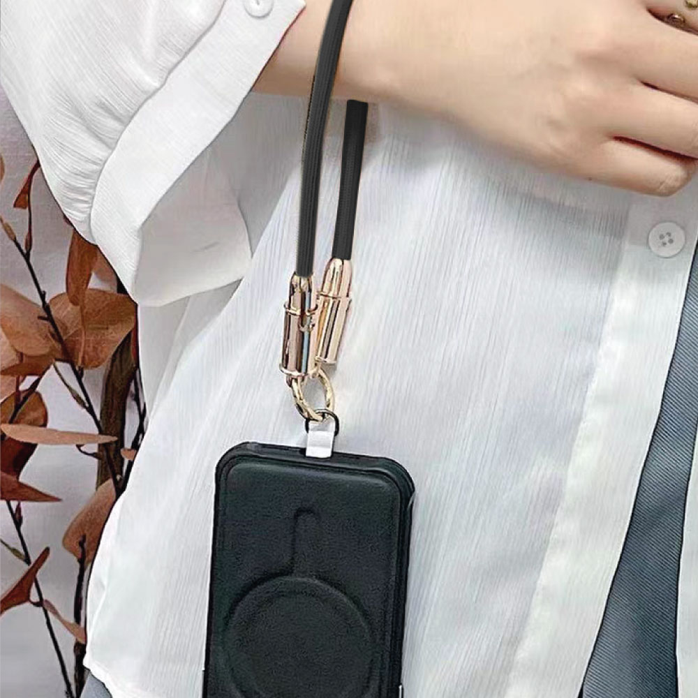 Mano de una persona sosteniendo un teléfono negro con un cordón negro. Camisa blanca en el fondo.