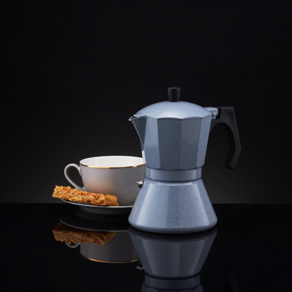 Kawiarka, filiżanka i ciastko. Niebiesko-biała kawiarka na czarnej powierzchni.