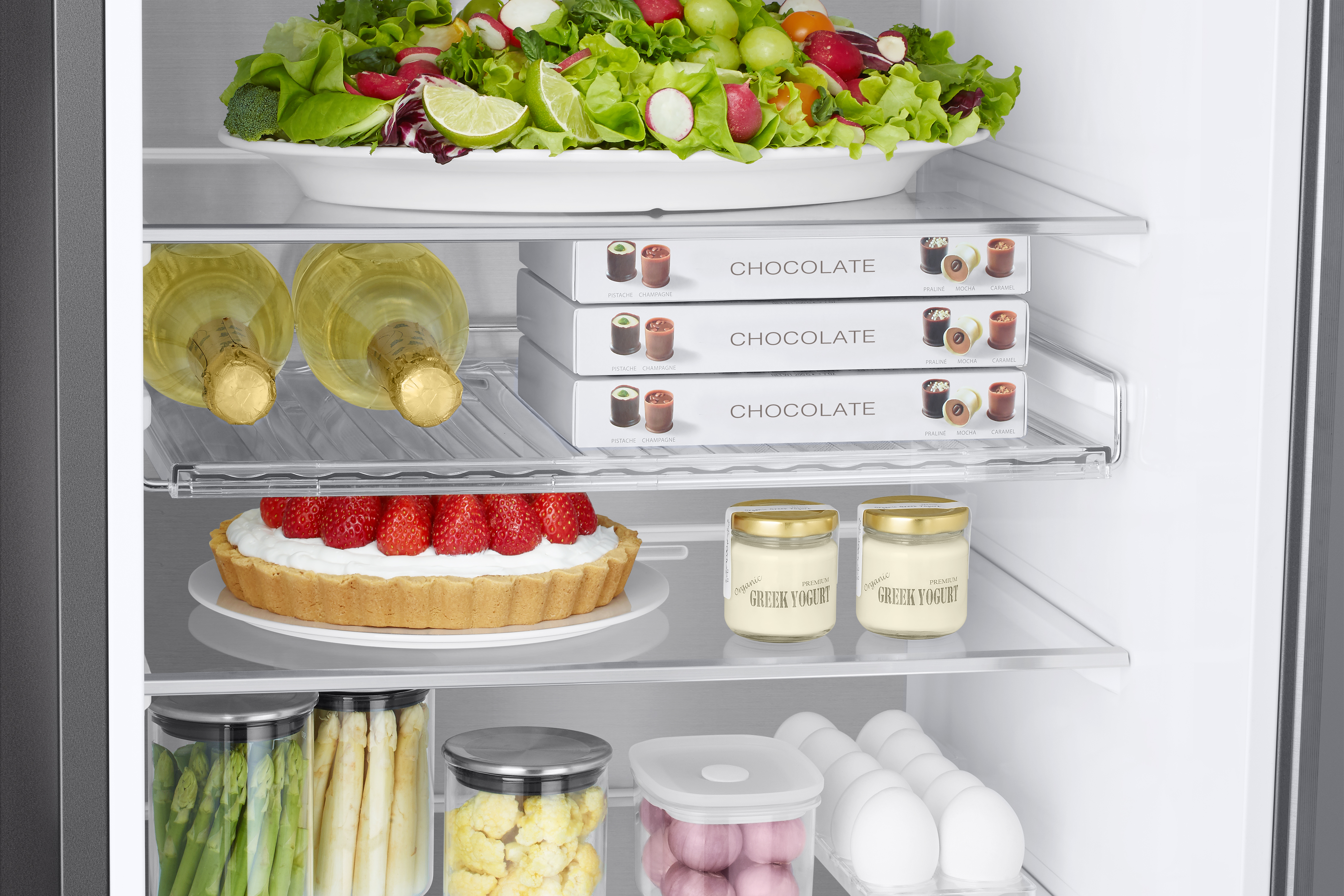 Kühlschrankinnenraum mit frischen Produkten, Desserts und Gourmetartikeln.