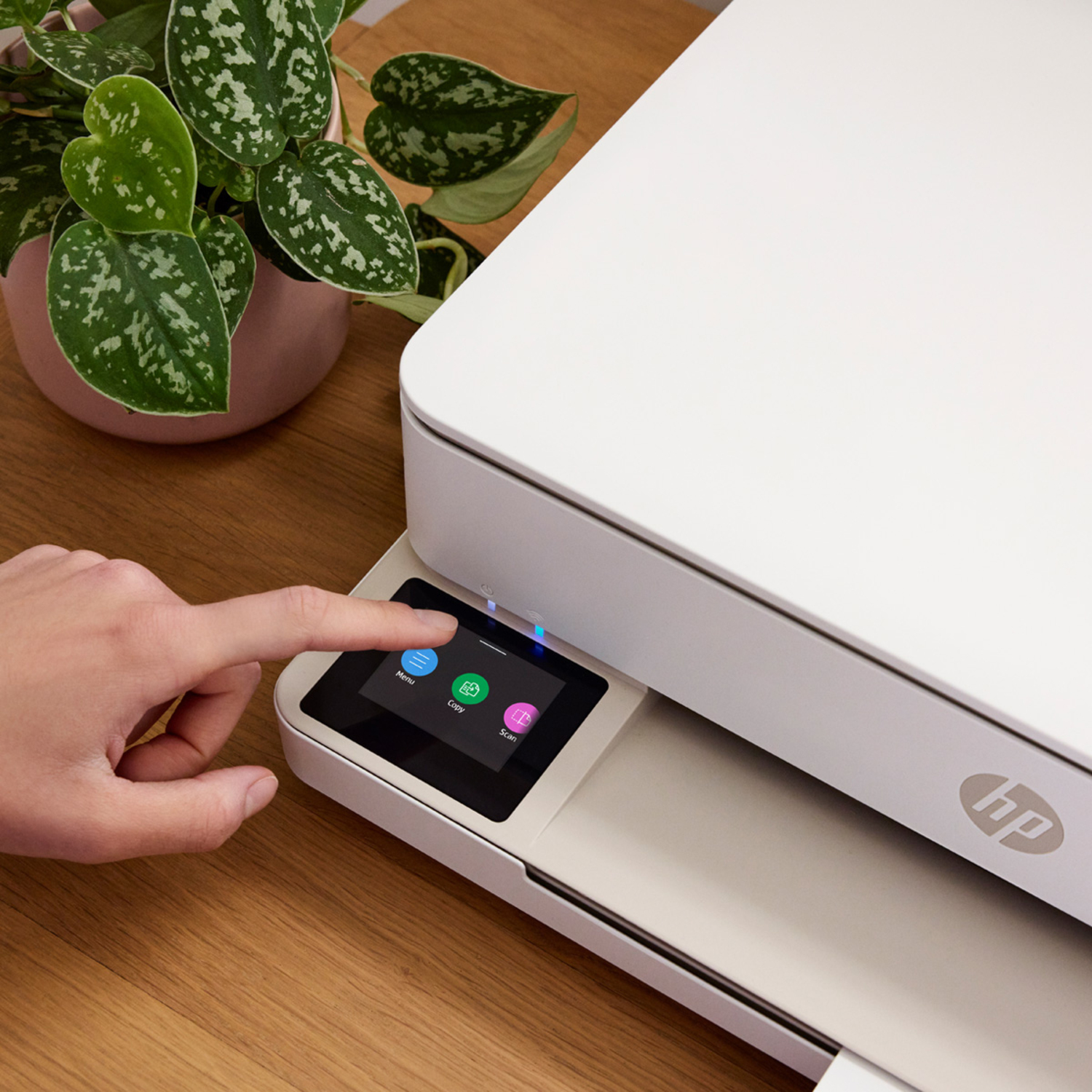 A printer with a hand touching the screen with three icons.