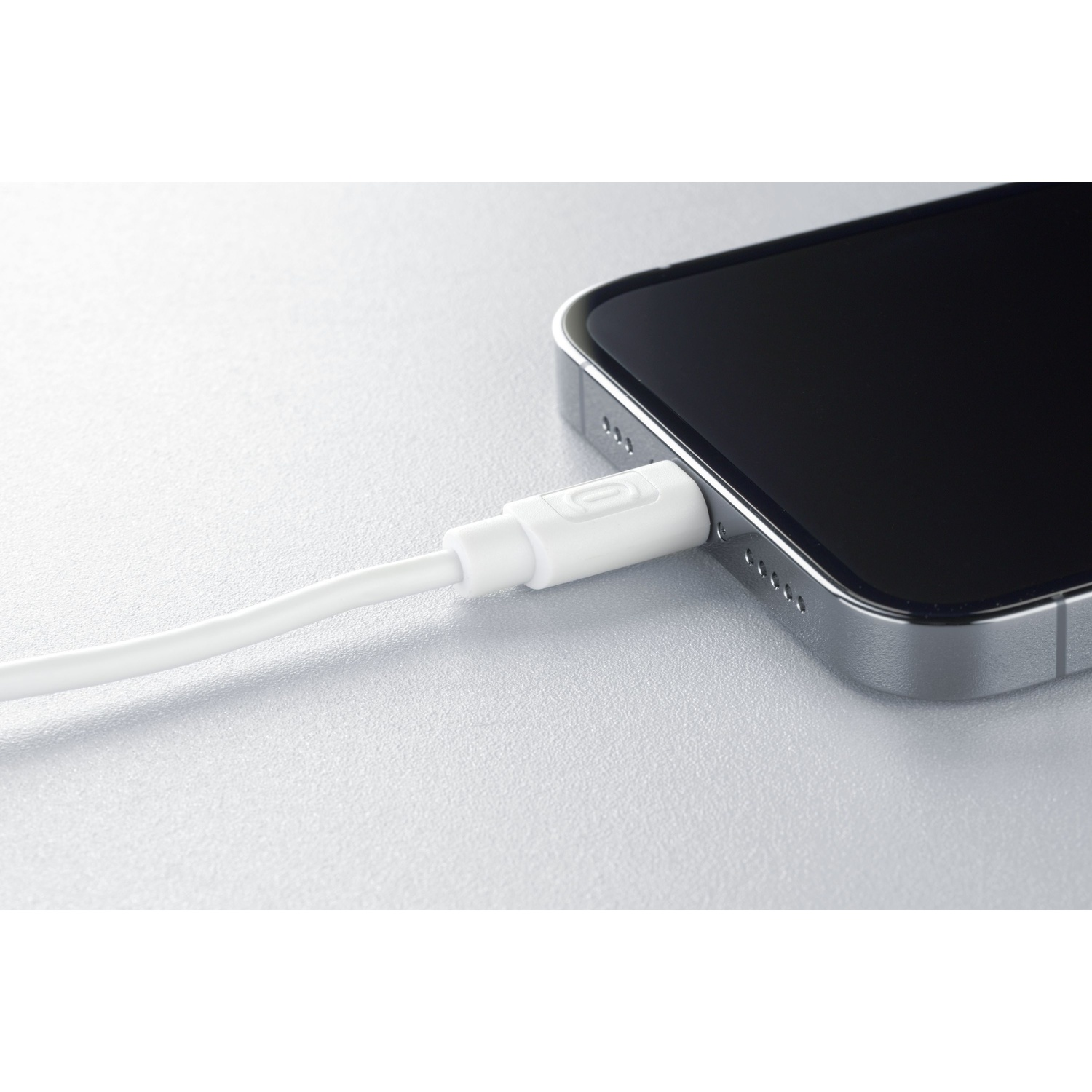 Un cavo di ricarica bianco collegato a uno smartphone argentato.