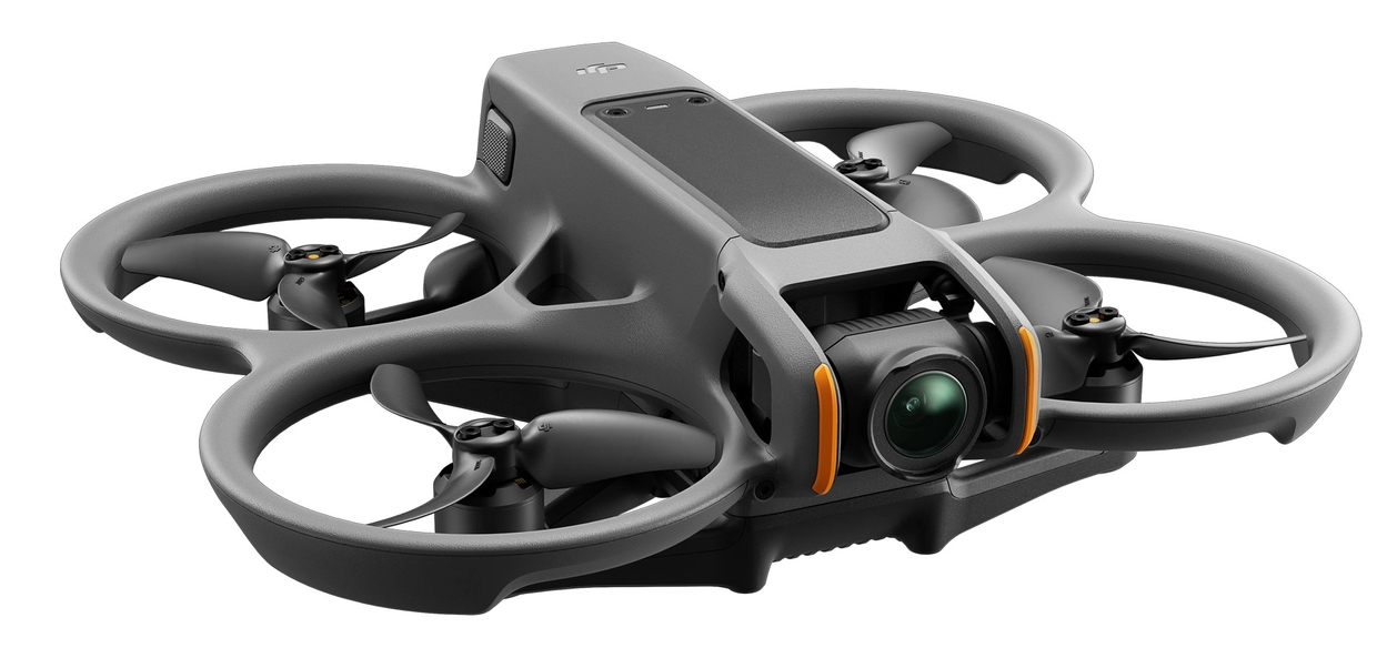 Szary dron z czterema śmigłami, kamerą i czarnym wierzchem. Dron jest na białym tle.