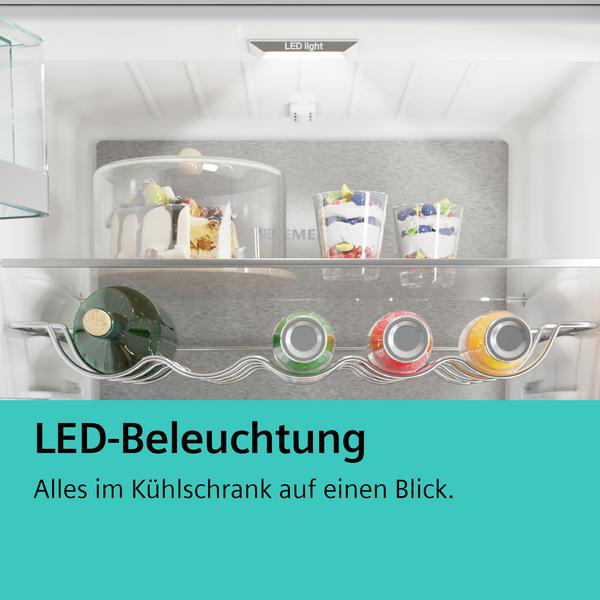 Kühlschrankinnenraum mit Regalen, Lebensmitteln und LED-Beleuchtung.