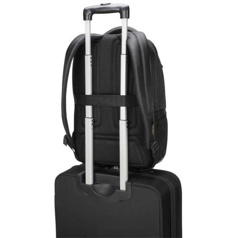 Una mochila negra encima de una maleta con ruedas. Se ve el asa de la maleta.