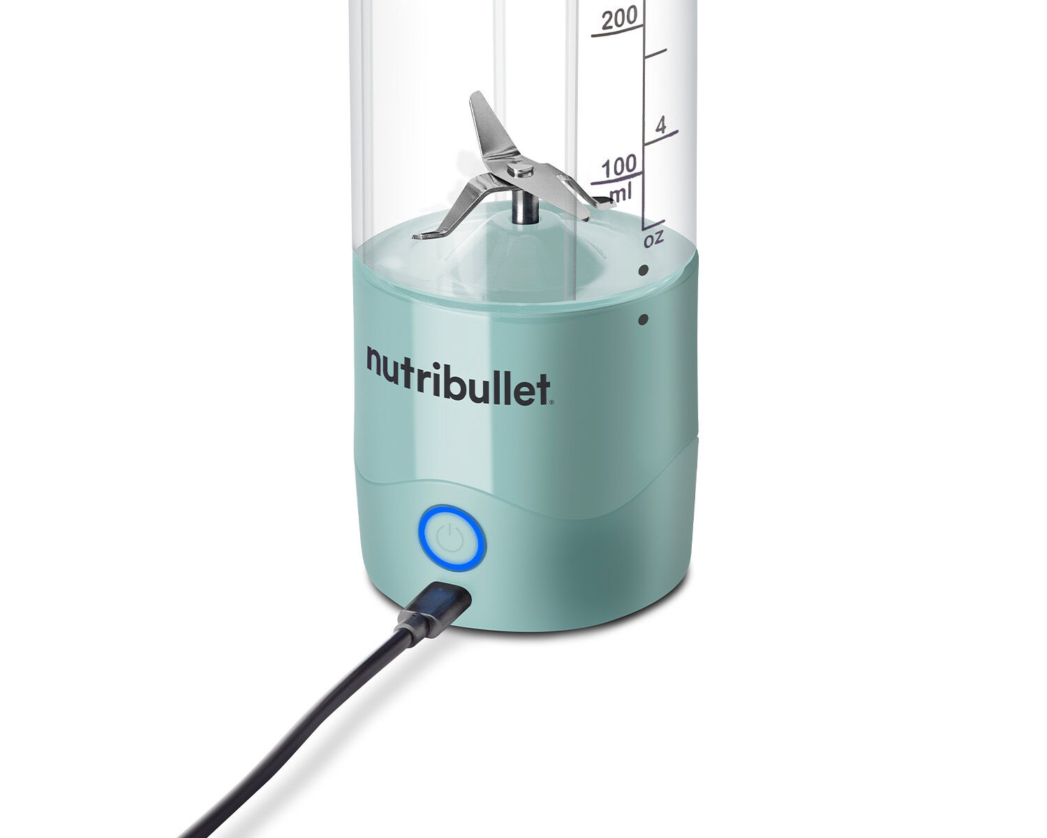 Licuadora Nutribullet turquesa con vaso transparente, cuchillas y cable de carga conectado.