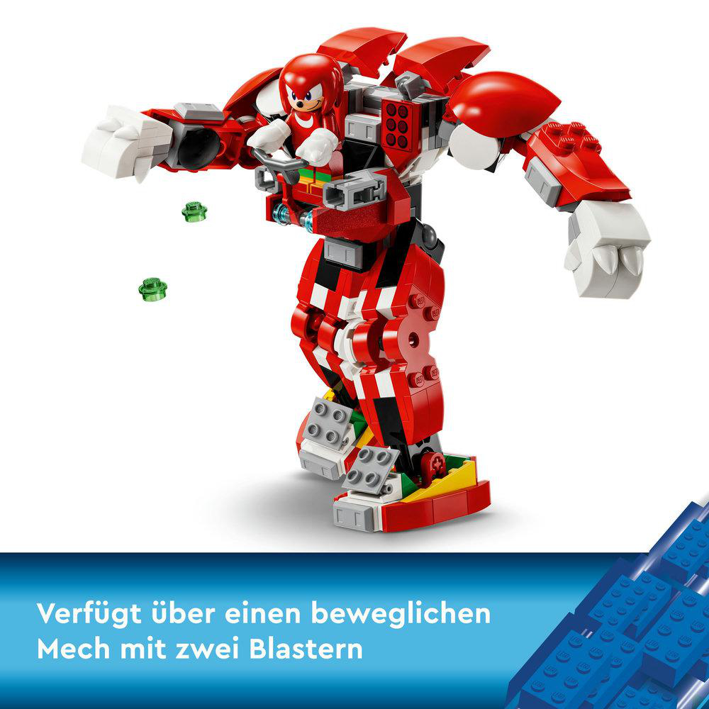 Rote und weiße Lego-Mech-Figur, mit kleiner Figur im Cockpit, und zwei grünen Objekten.
