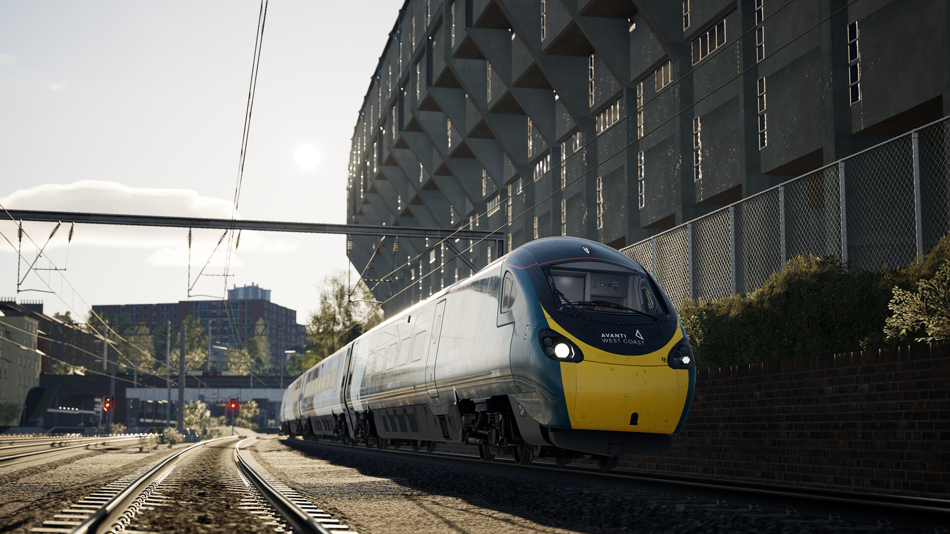 Un treno moderno con la parte anteriore gialla si muove lungo un binario, con un edificio sullo sfondo.