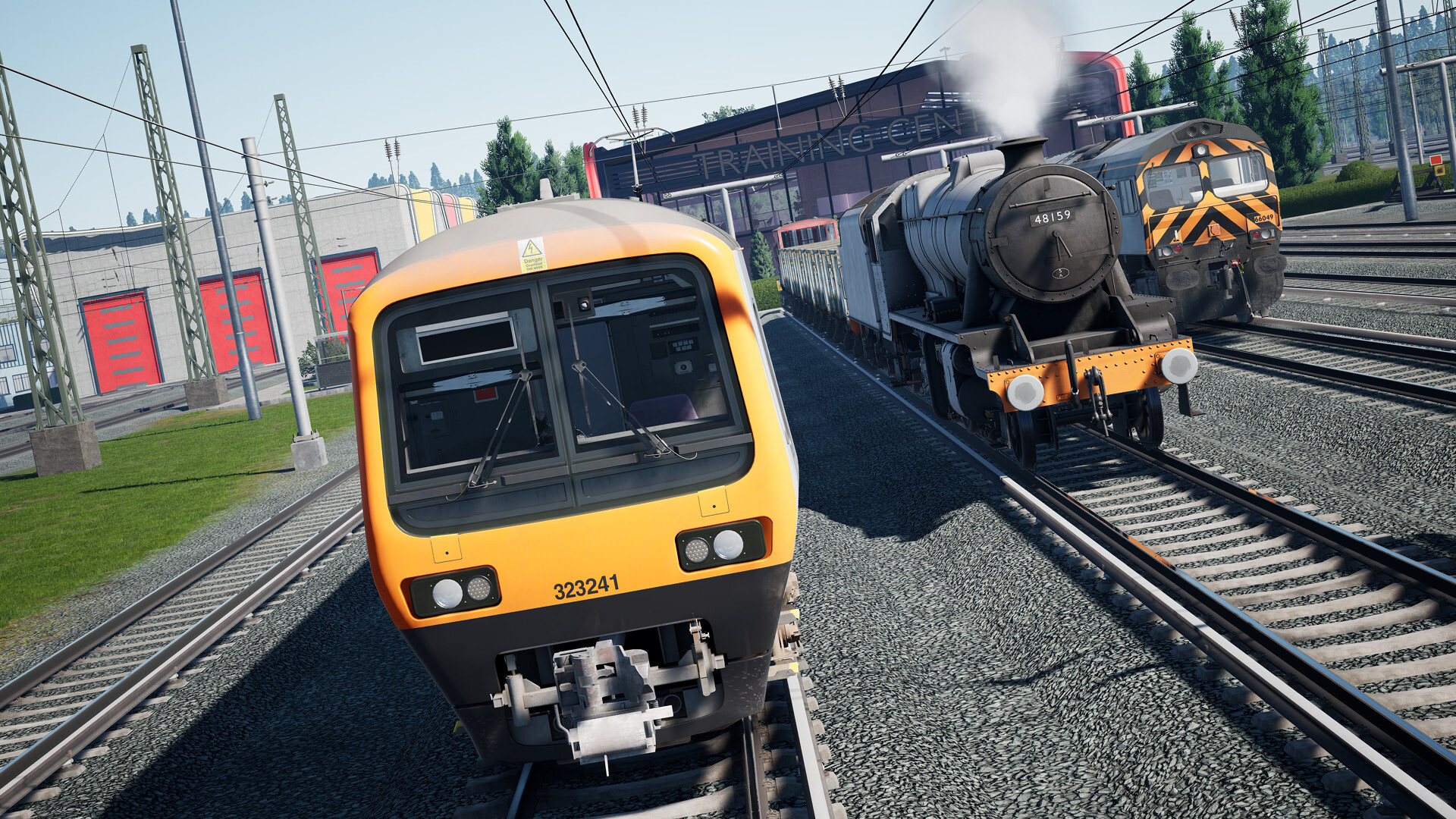 Tre treni sui binari: arancione, a vapore e diesel nero. Edifici sullo sfondo, giornata di sole.