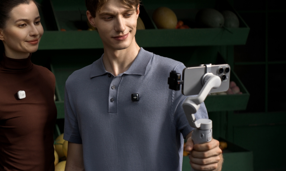 Dwie osoby używające smartfona z gimbalem i mikrofonami bezprzewodowymi.