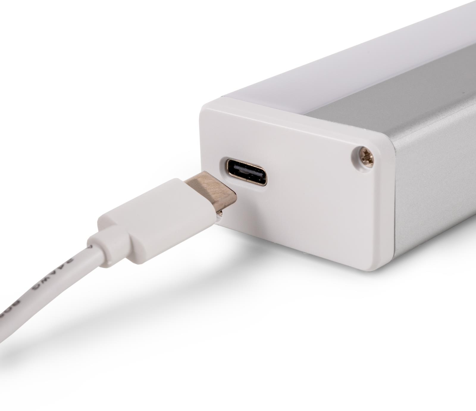 Fehér USB-C kábel egy ezüst-fehér eszköz oldalába dugva.