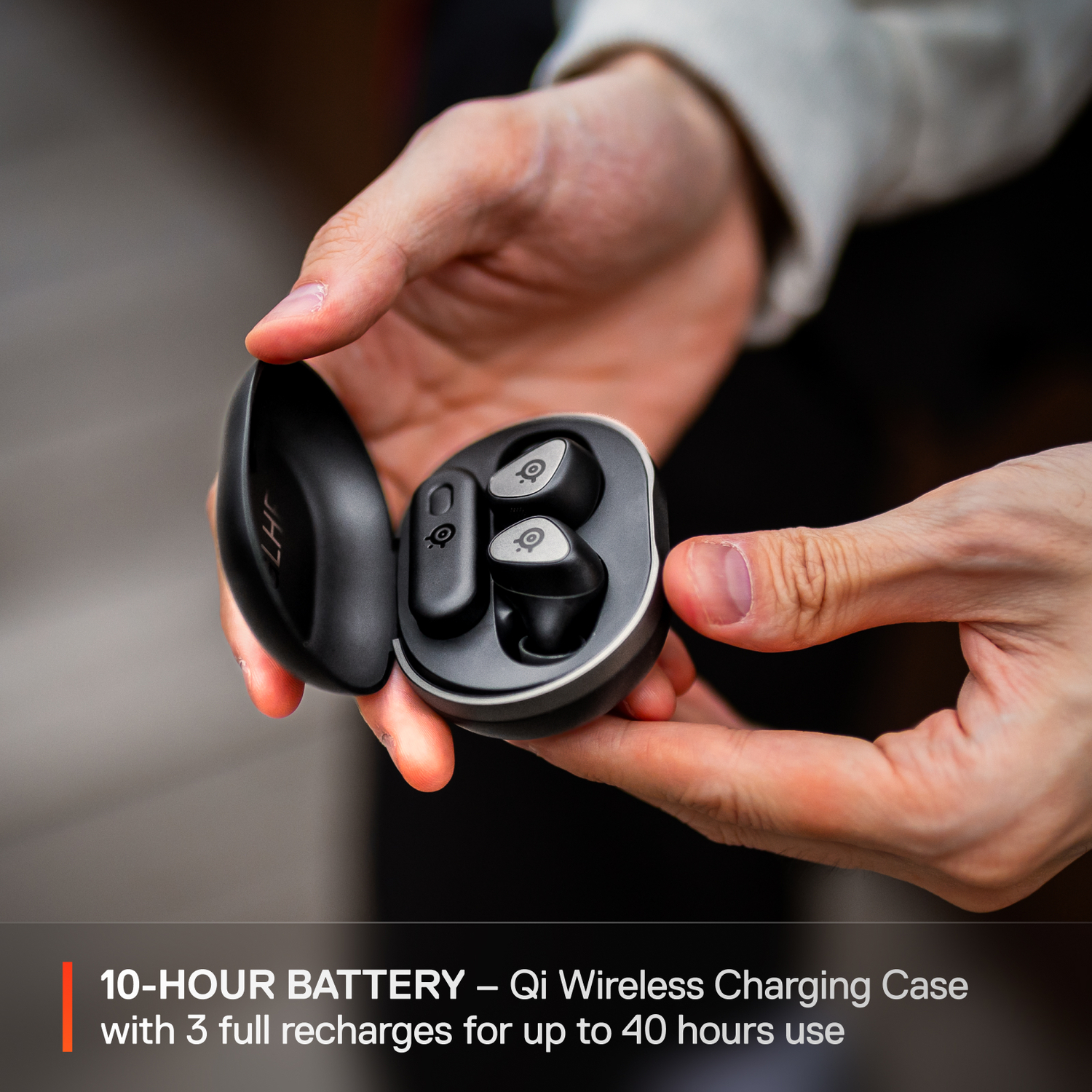 Hands holding a black charging case with earbuds. Text overlay.