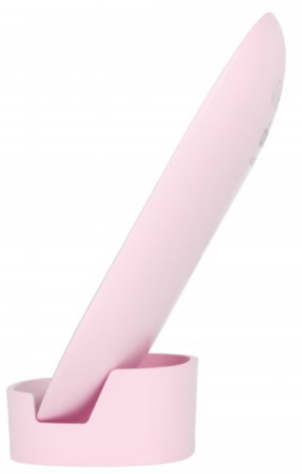 Różowe urządzenie, prawdopodobnie narzędzie do stylizacji włosów, w pasującym różowym stojaku. Jest ustawione pod kątem.