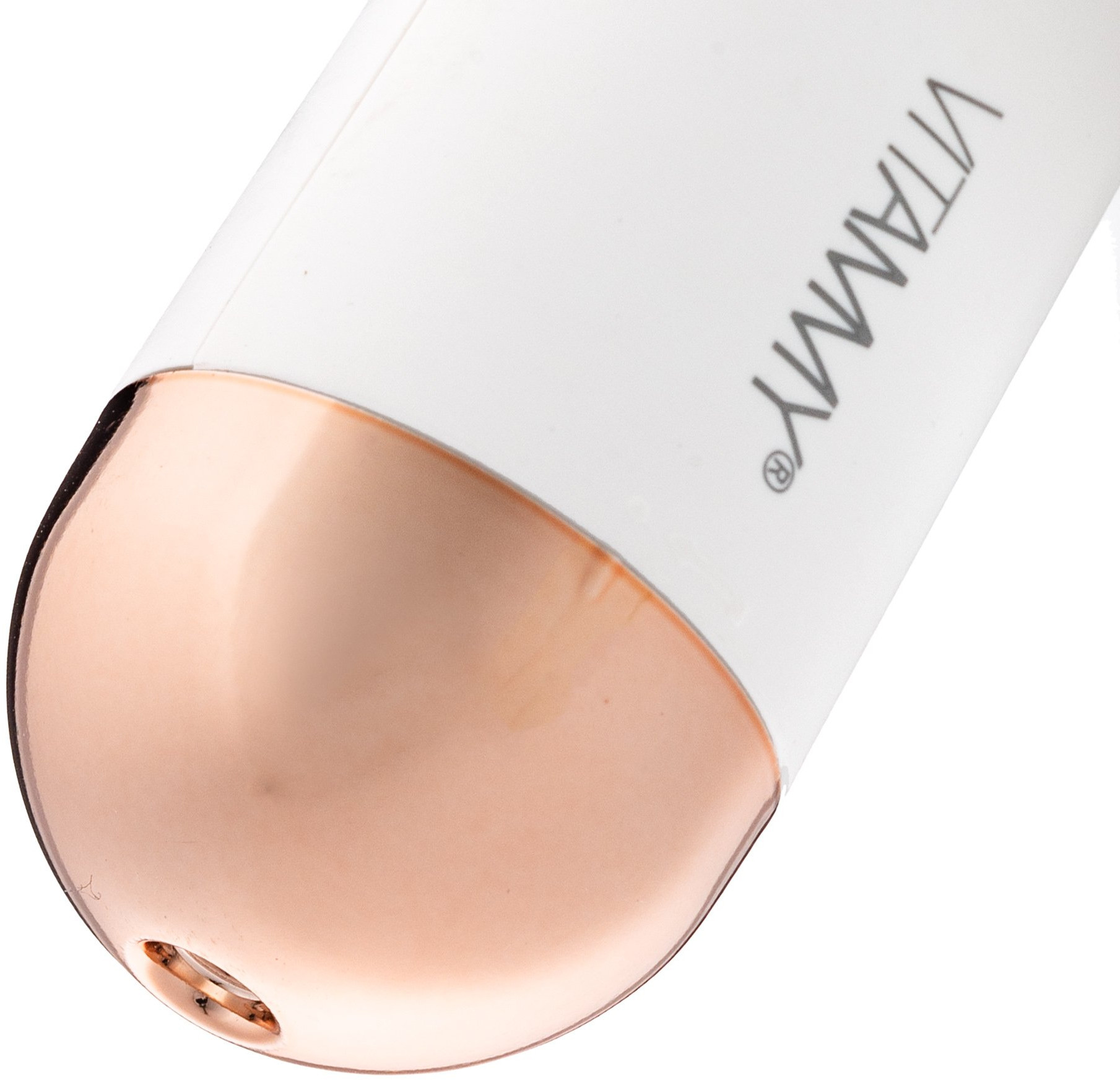 Zbliżenie białego urządzenia ze złotą końcówką. Słowo VITAMY na urządzeniu.