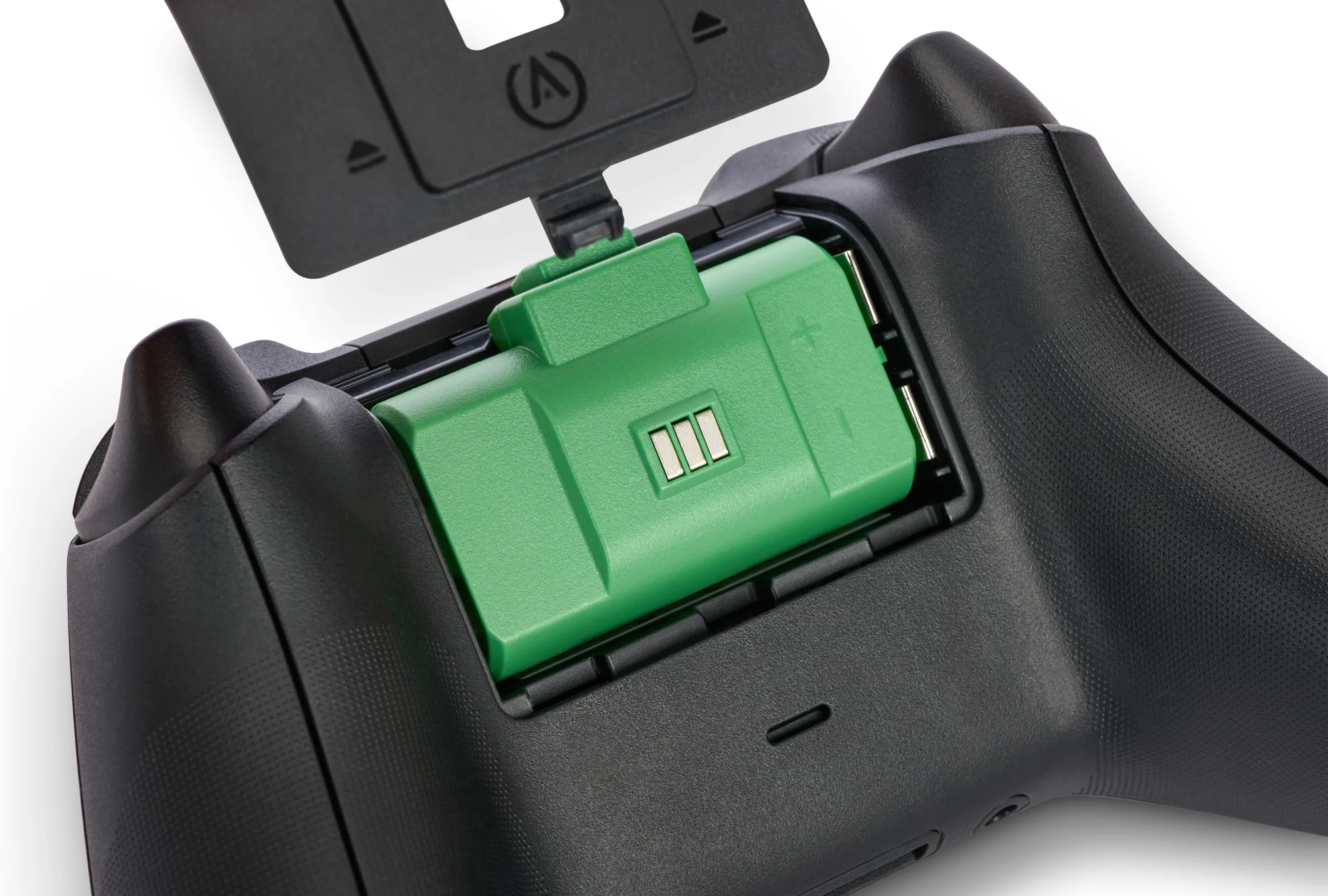Otwarty kontroler Xbox z zielonym akumulatorem widocznym wewnątrz komory baterii.