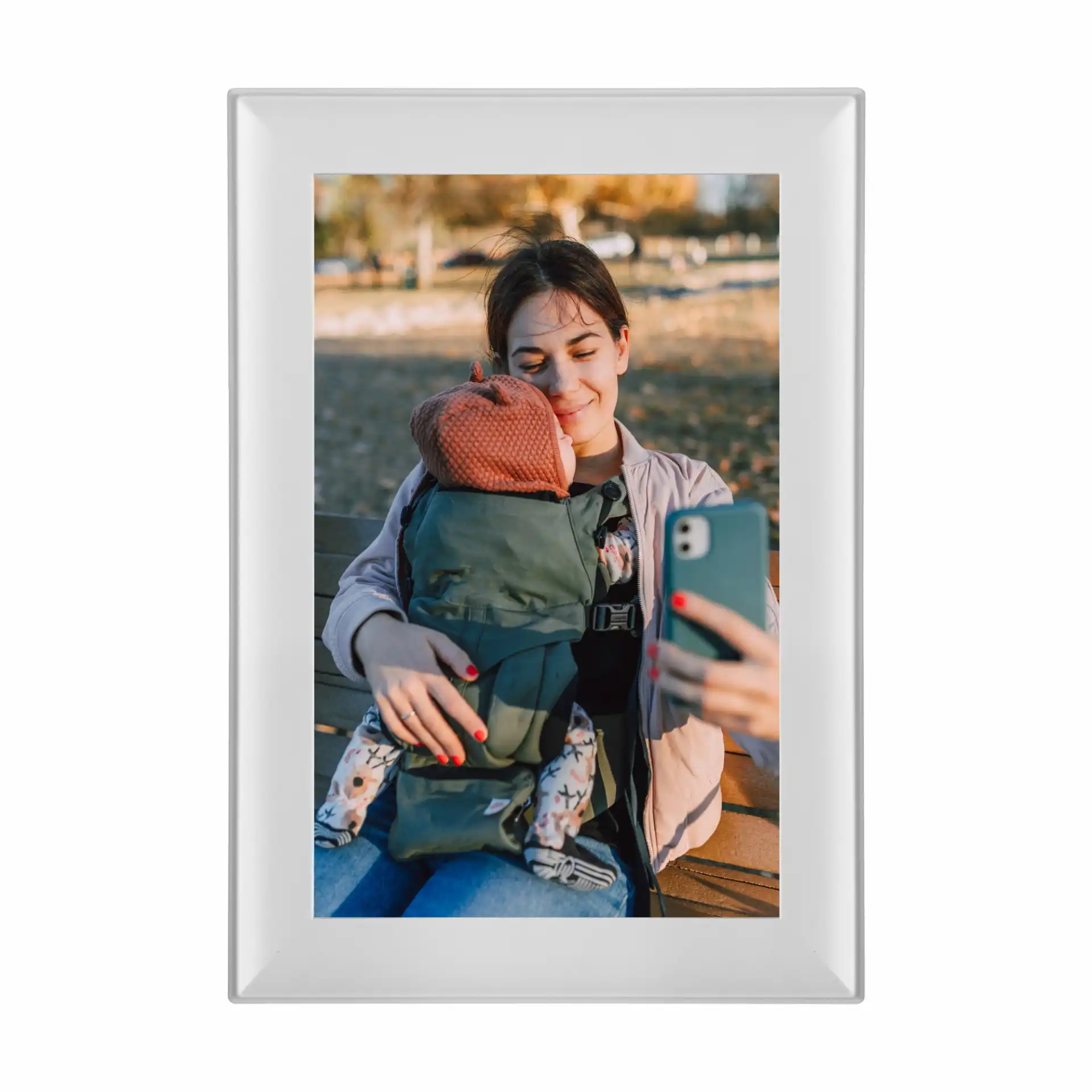 Ein gerahmtes Bild mit einer Mutter, die ein Selfie mit ihrem Baby auf einer Parkbank macht.