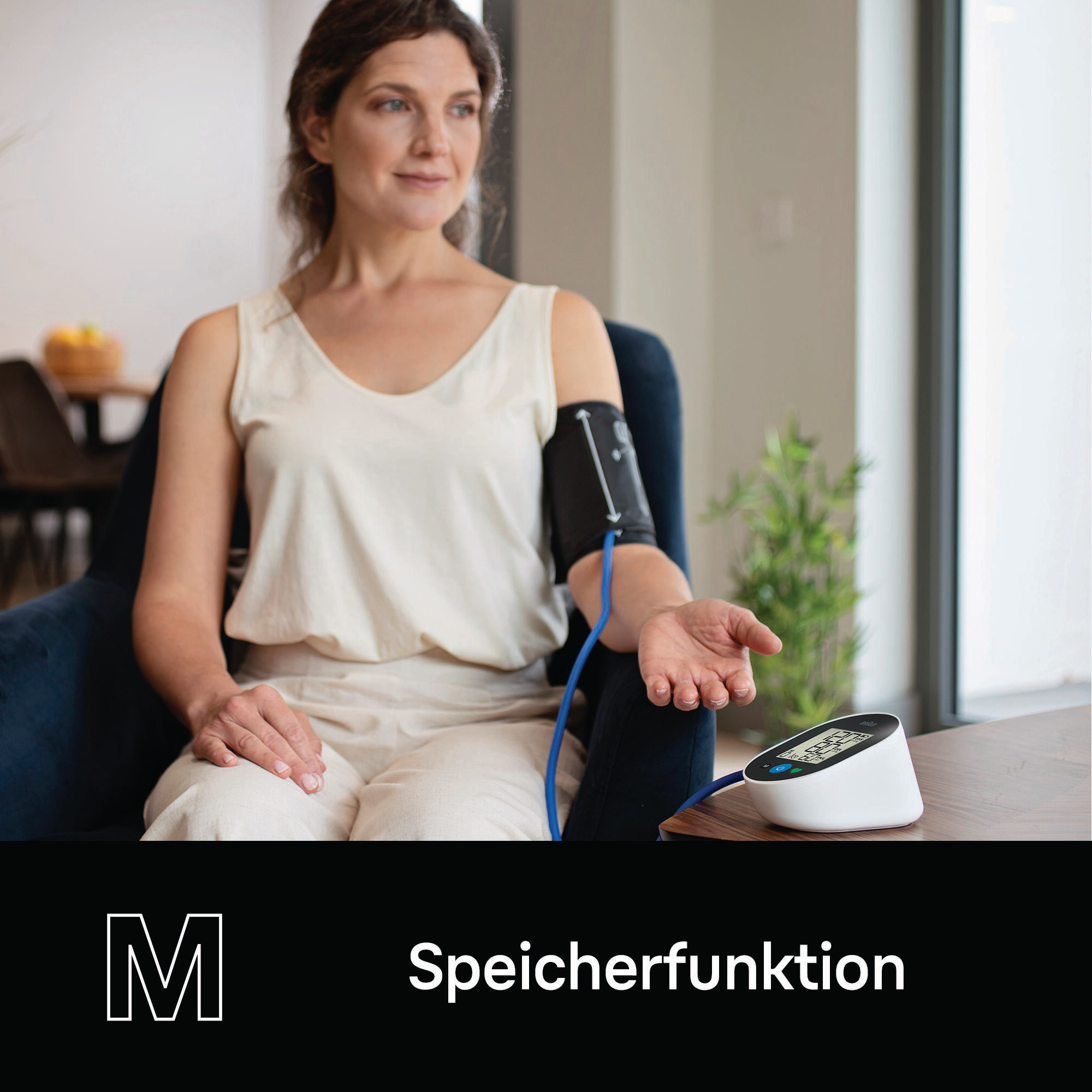 Frau in weißem Top, Blutdruckmessgerät am Arm, Gerät auf dem Tisch, Innenszene.
