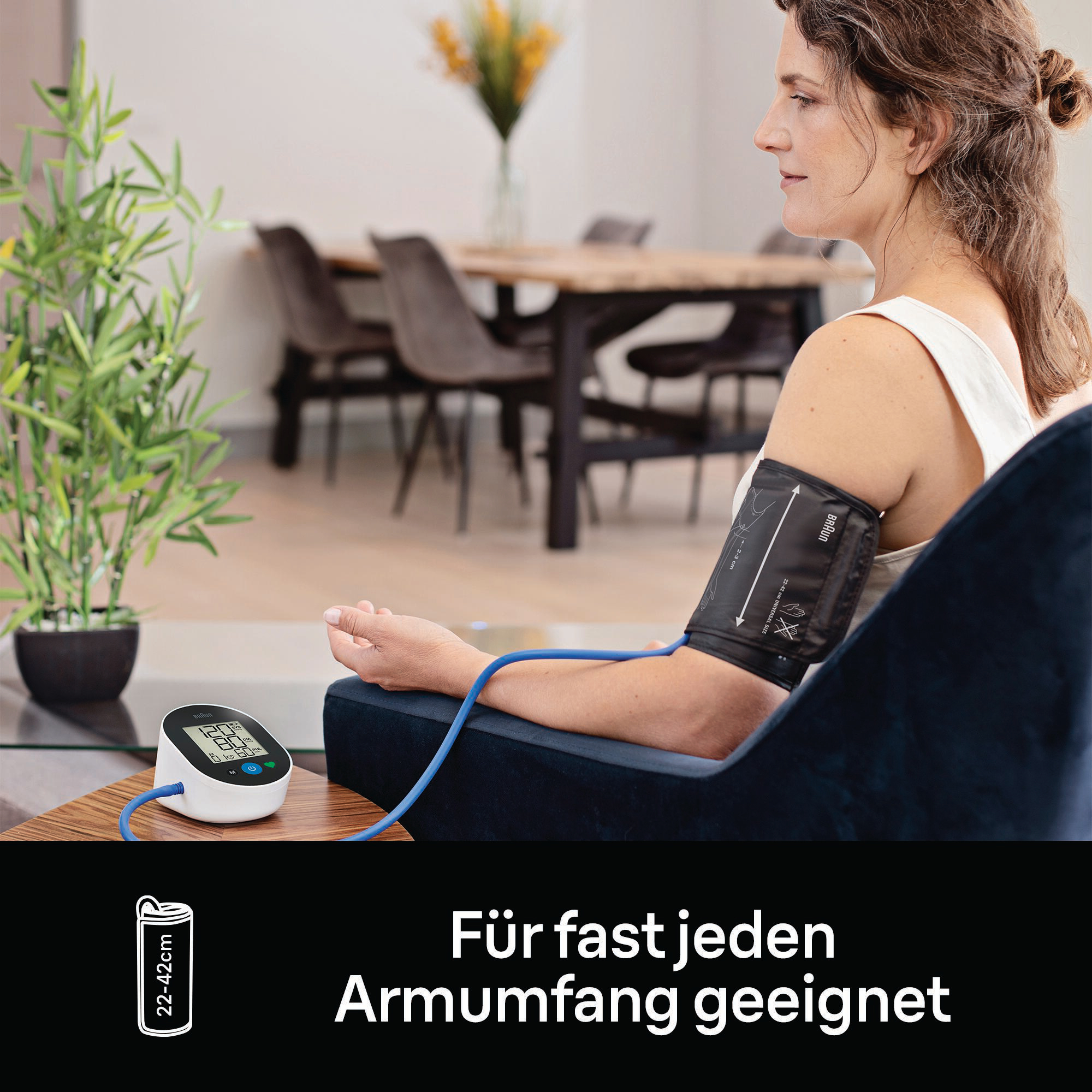 Frau, die den Blutdruck mit einem Monitor und einer Manschette misst.