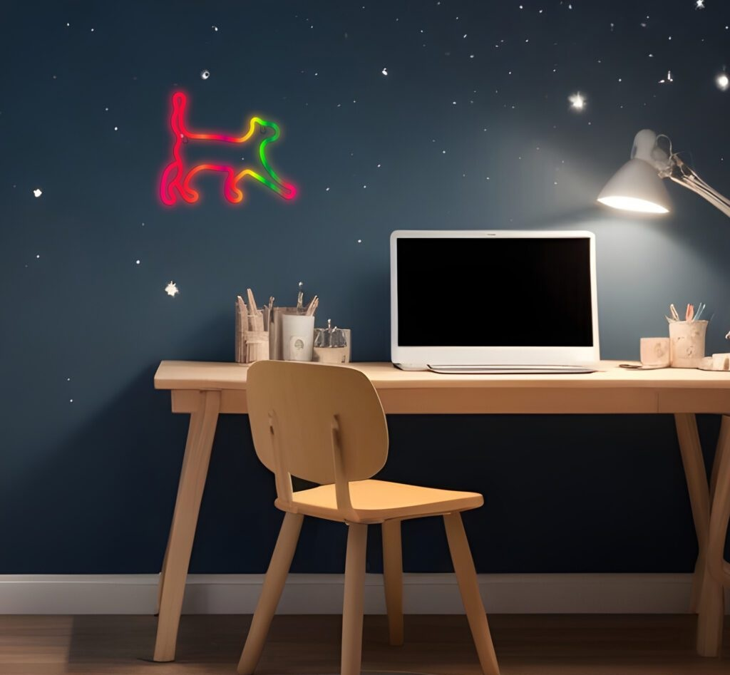 Biurko z laptopem, lampą i neonową sylwetką kota na ścianie. Ciemnoniebieska ściana, gwiazdy.