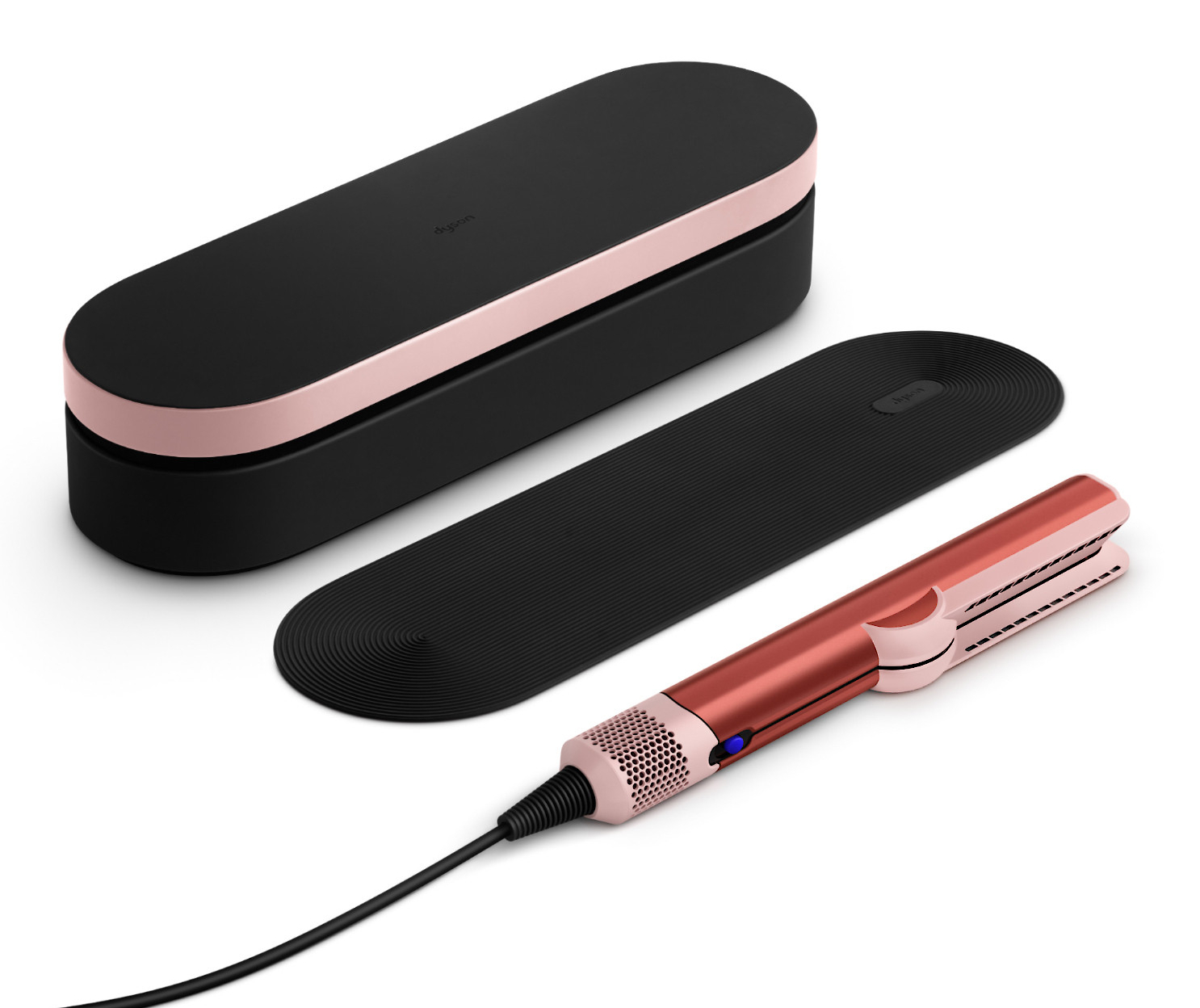 Zestaw prostownicy Dyson z etui, matą termiczną i prostownicą w kolorze różowego złota i czerni.
