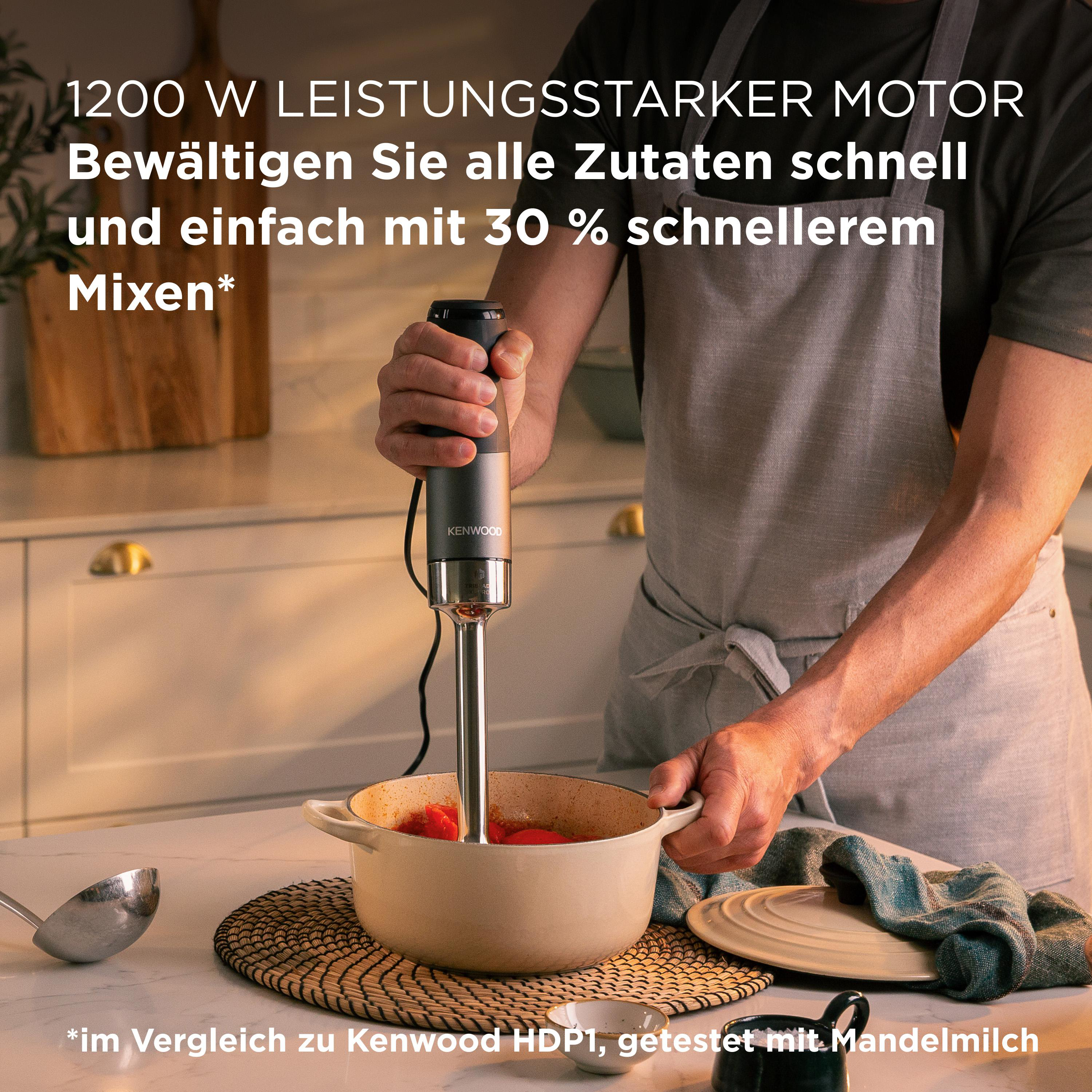 Eine Person verwendet einen Kenwood-Stabmixer in einem Topf mit Tomaten.