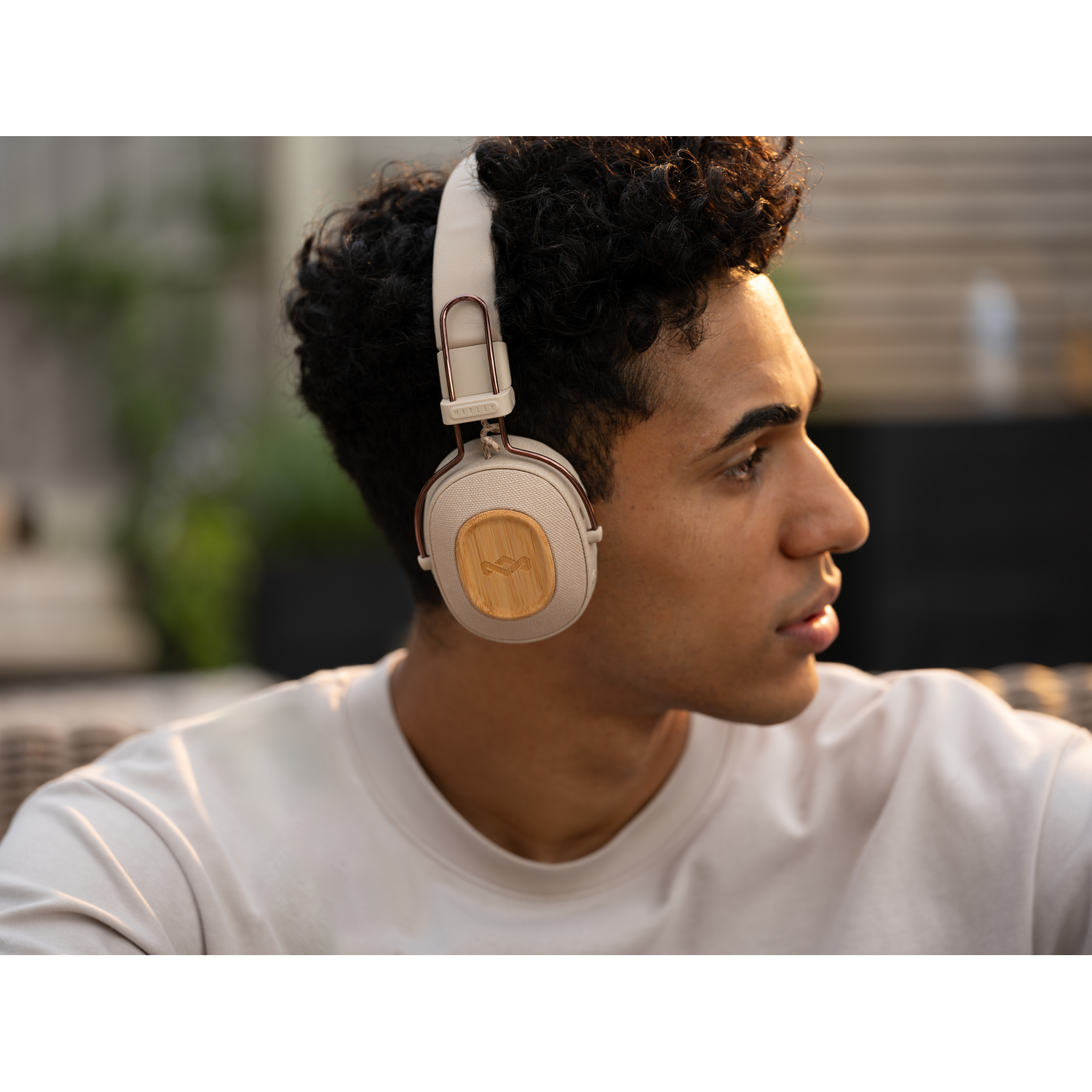 Un homme portant un casque beige avec un panneau en bois, regardant sur le côté.