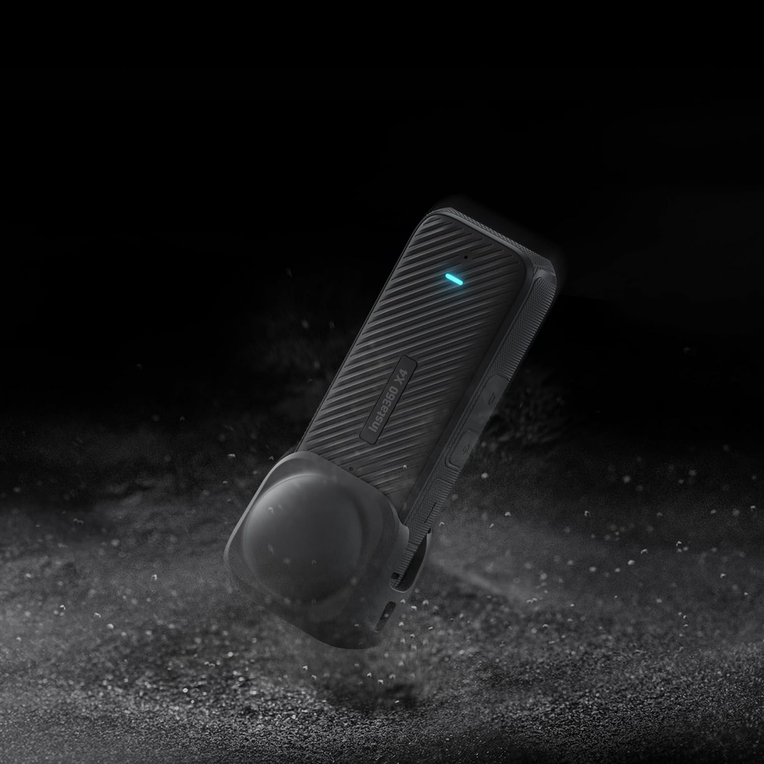 Cámara negra Insta360 X4 cayendo en un entorno oscuro. Cámara pequeña con funda protectora.