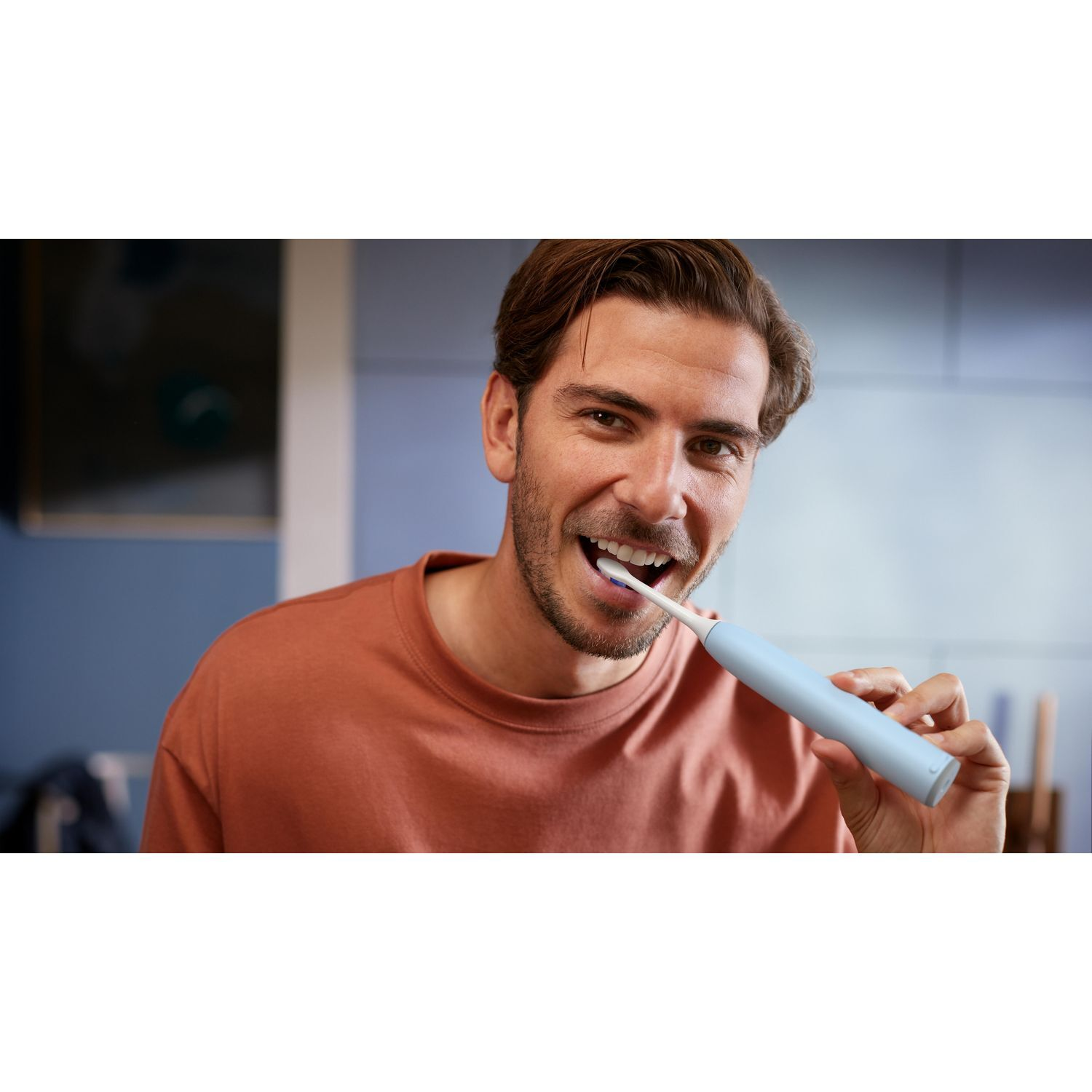 Homme se brossant les dents avec une brosse à dents bleue.