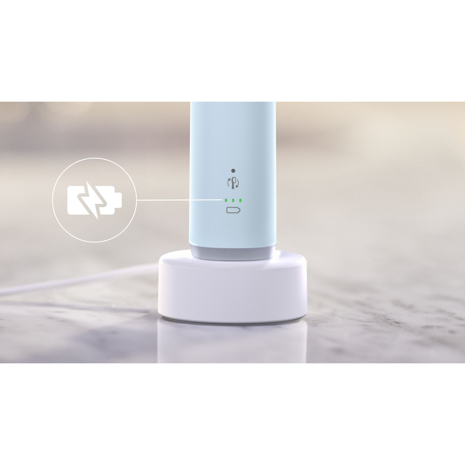 Une brosse à dents électrique sur une base de chargement blanche. La base est sur une surface en marbre.