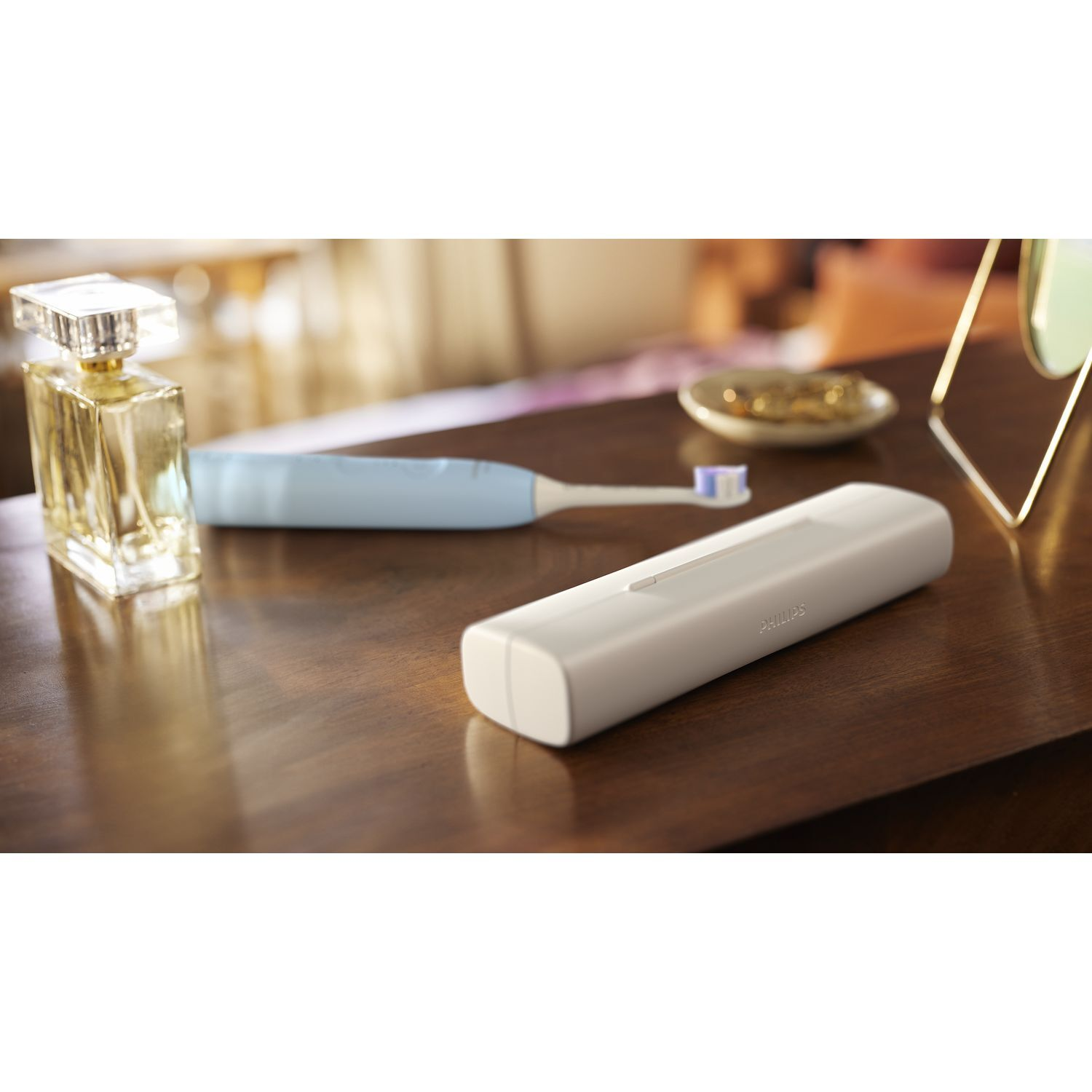 Brosse à dents, étui, parfum et bijoux sur une surface en bois.