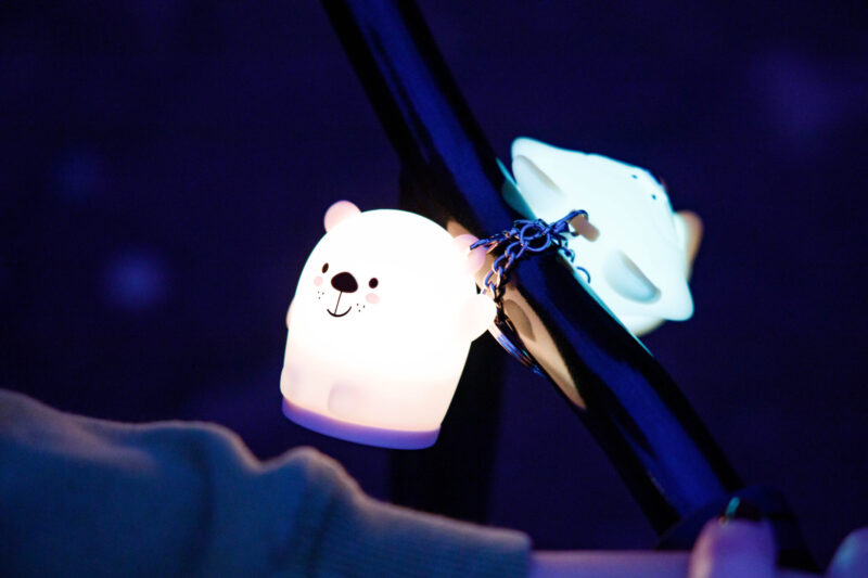 Dwa świecące światła na ciemnym tle. Jedno to biały miś; drugie to biała gwiazda.