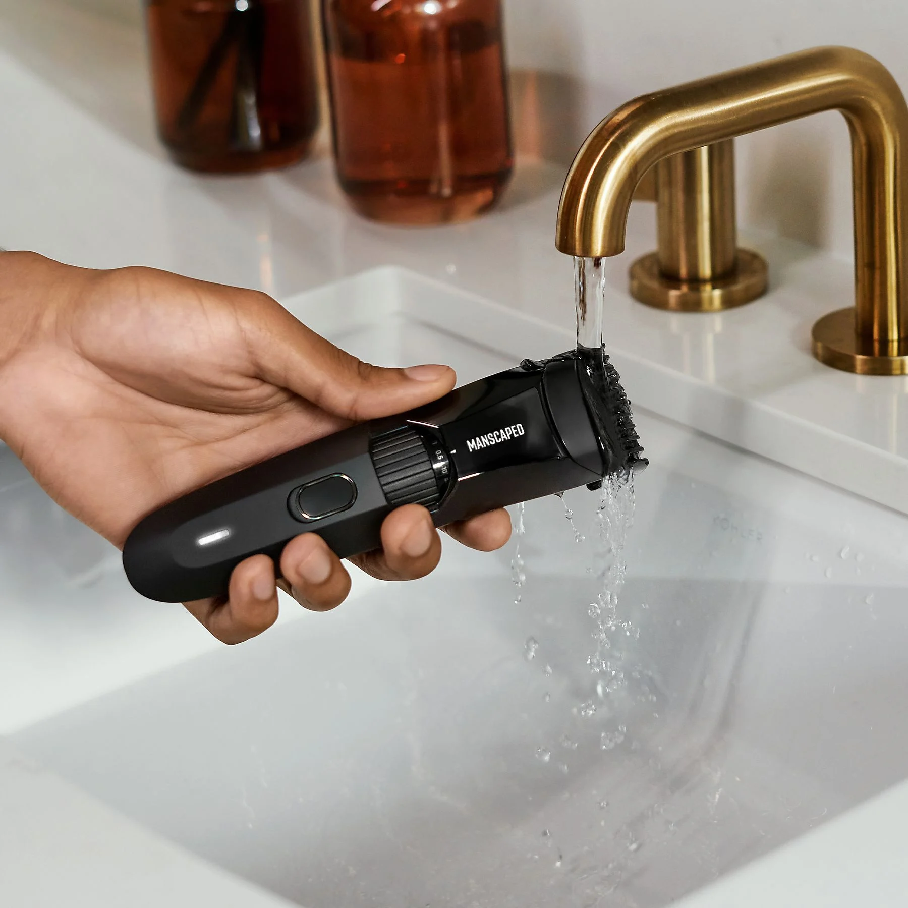 Tondeuse Manscaped nettoyée avec de l'eau au-dessus d'un évier.