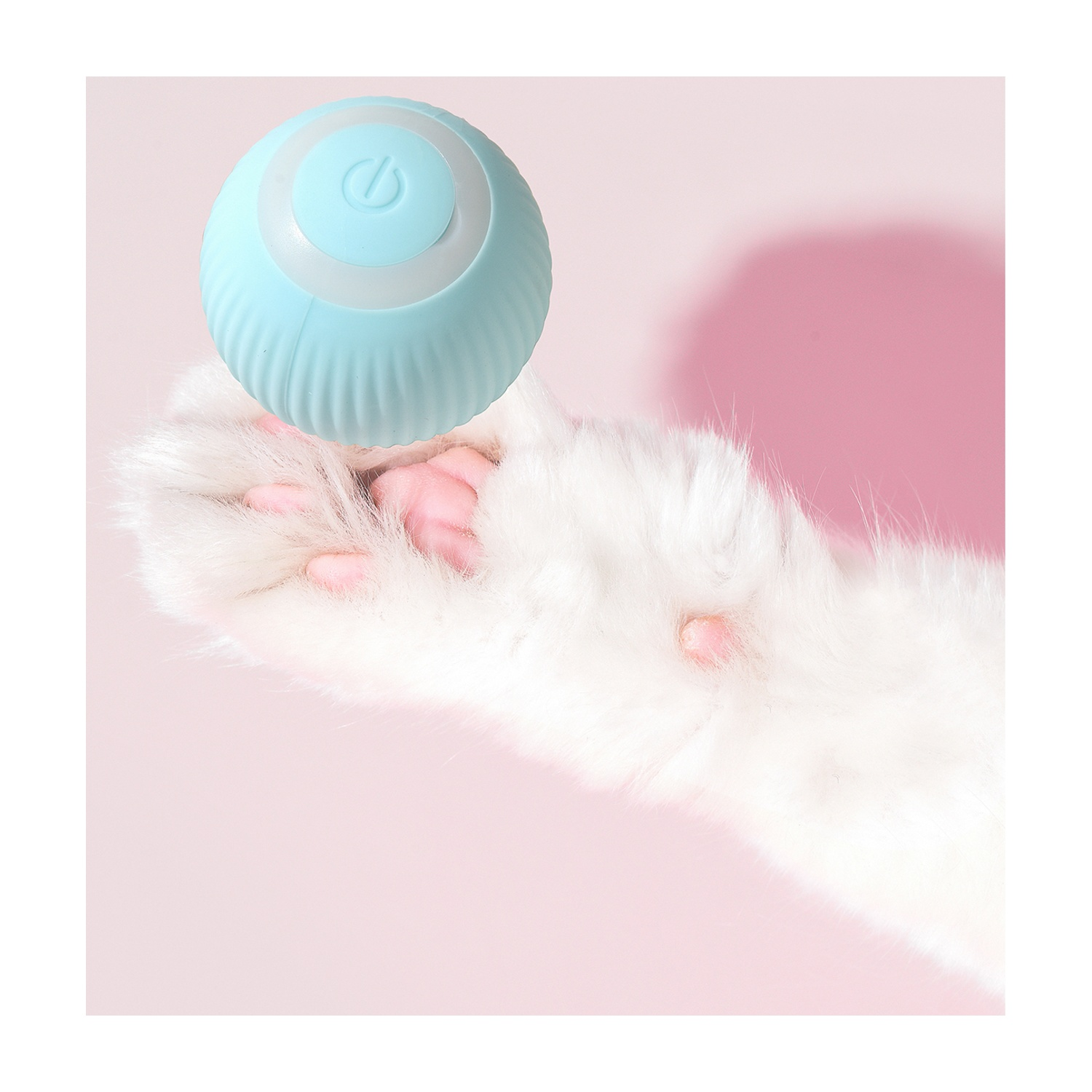 Una zampa di gatto con una palla blu. Sfondo rosa.