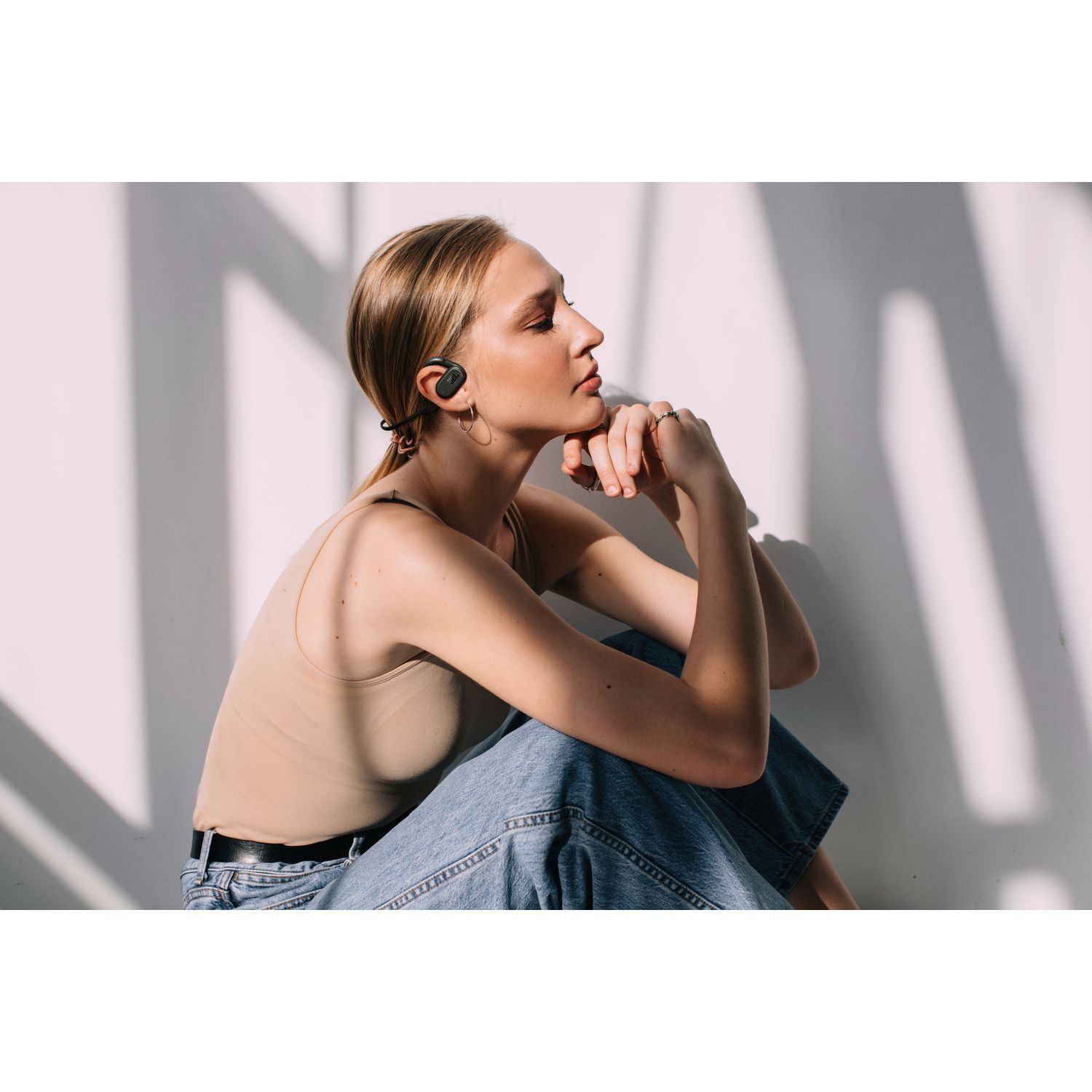 Une femme aux cheveux blonds portant un casque assise.