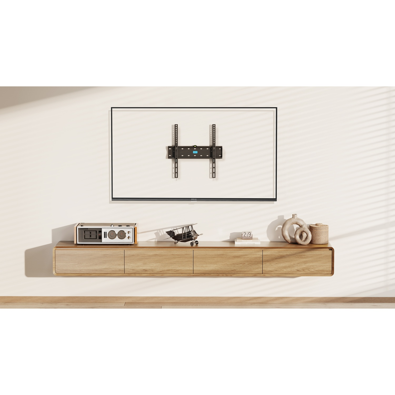 Una TV montata su una parete. Sotto c'è una console in legno. C'è un altoparlante sulla console.