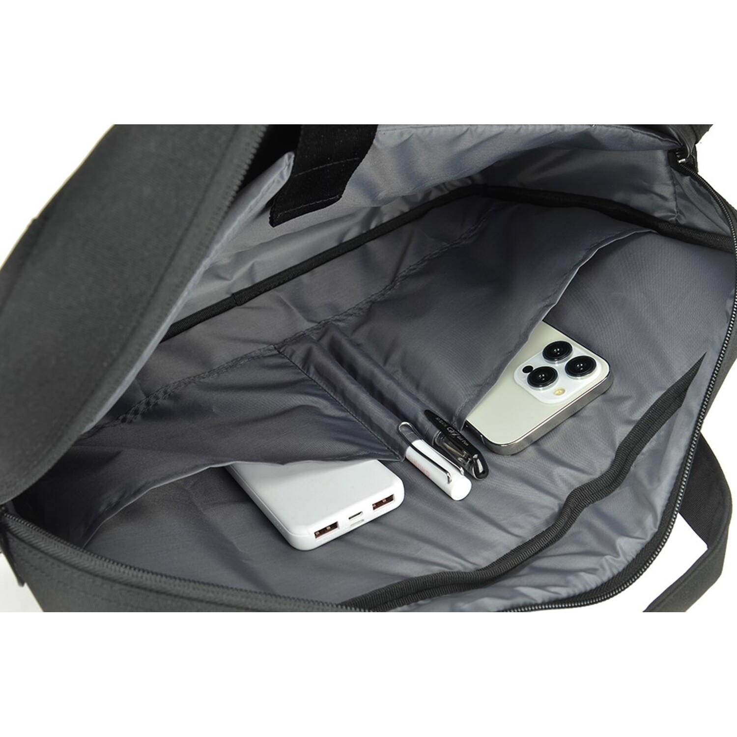 Open black bag interior with a phone, charger, pens, and a white power bank.