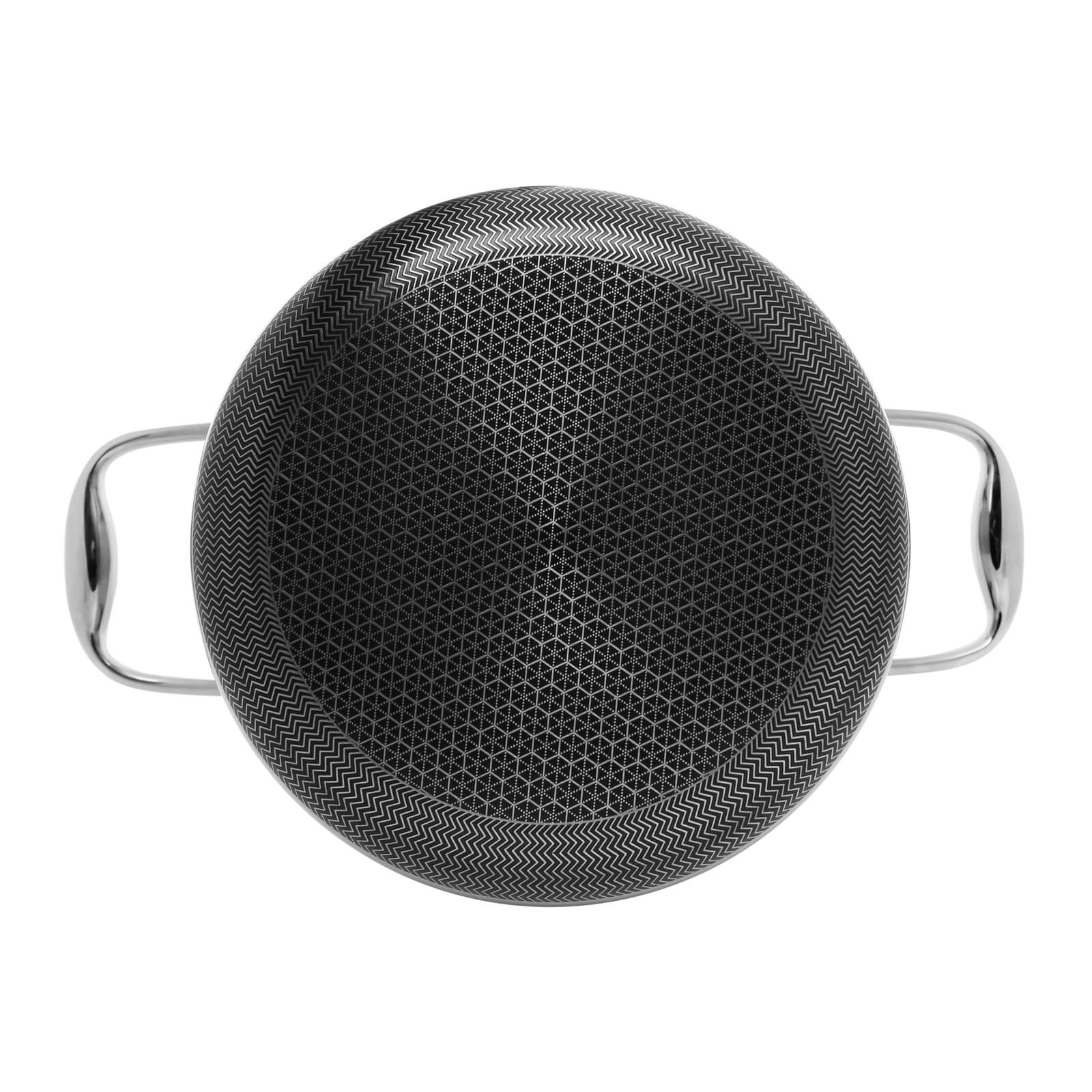 Czarny garnek z dwoma srebrnymi uchwytami. Powierzchnia do gotowania jest wzorzysta.